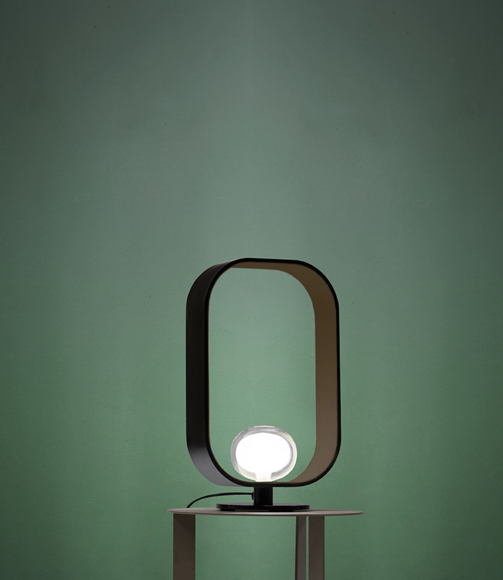 Filipa Tischleuchte von Tooy: Moderne Designerlampe mit ovalem Rahmen und leuchtender Kugel.