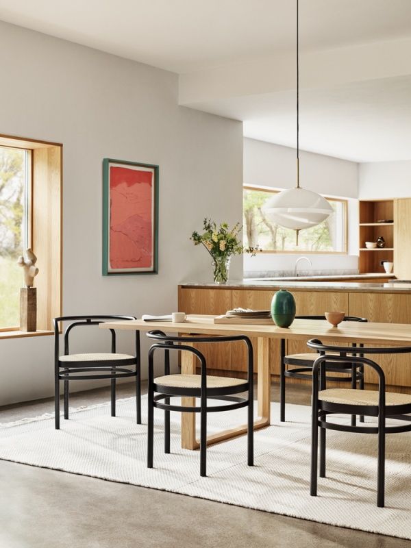 Esszimmer mit PK 15 Stühlen von Fritz Hansen, schwarzes Metallgestell und Rattan Sitzfläche.