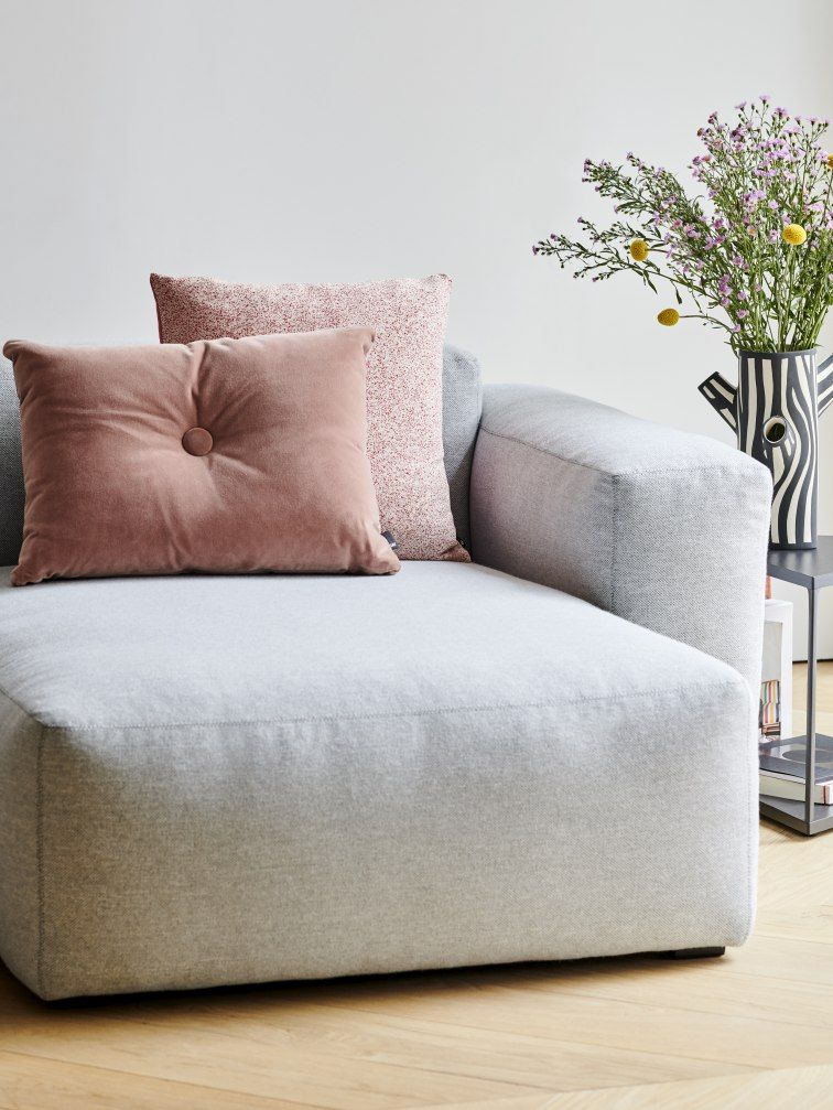 Beiges Mags Soft Sofa mit Kissen und Blumen, modernes Wohnzimmer-Interieur.