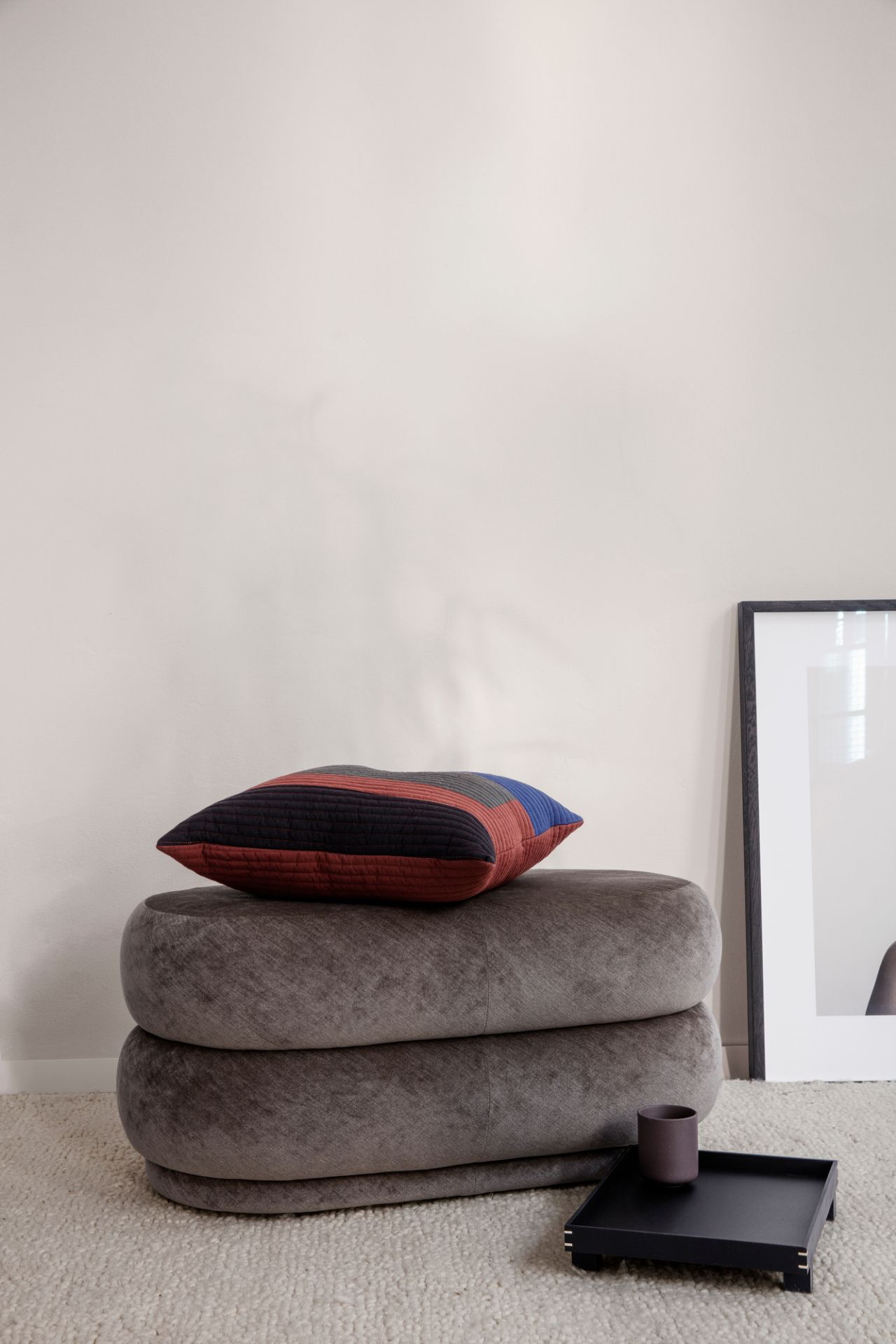 Ovaler Pouf Hocker "Forest" von Ferm Living aus Samt mit Kissen und Tablett.