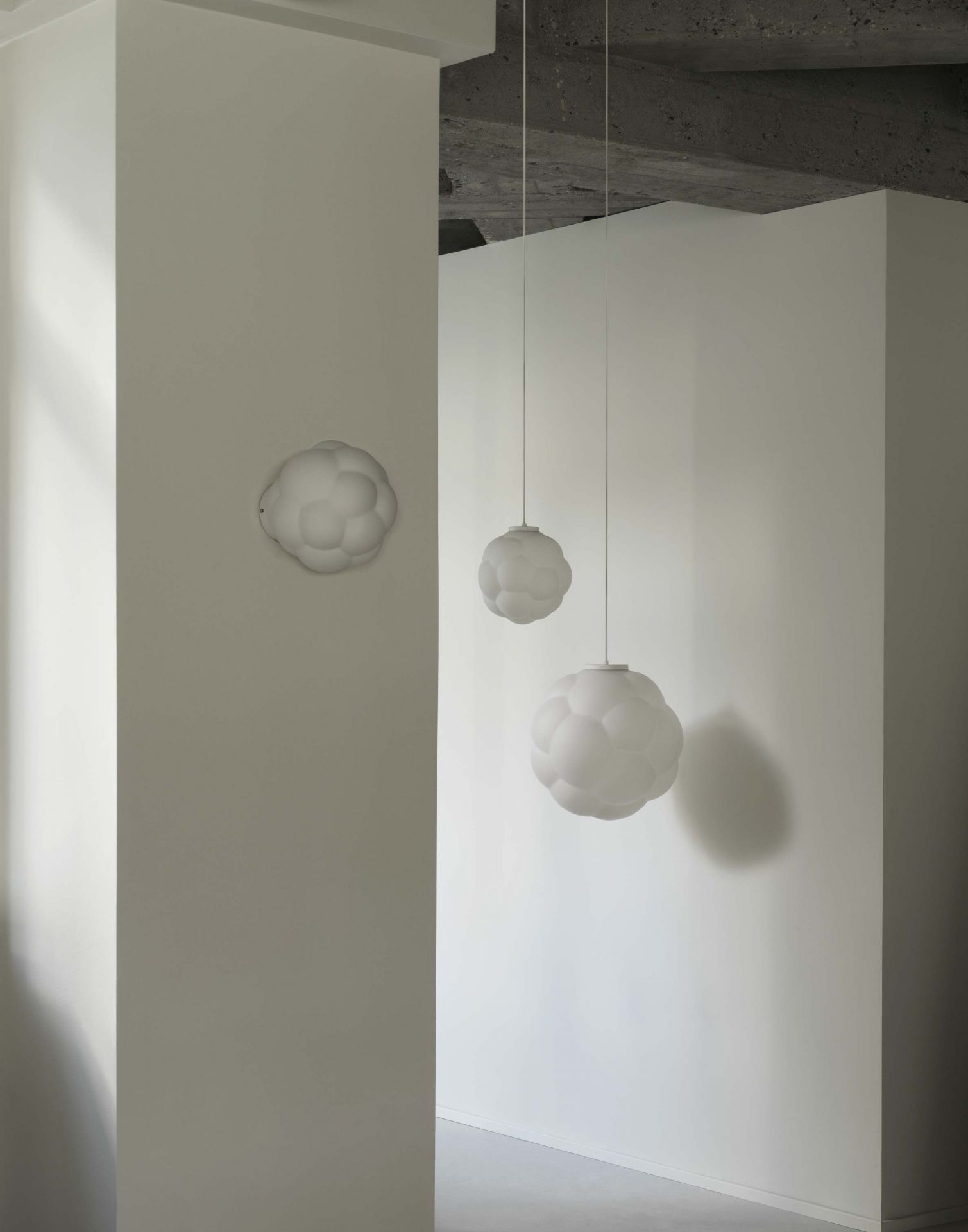 Zwei Bubba Pendelleuchten von Normann Copenhagen, weiße Designerleuchten im minimalistischen Interieur.
