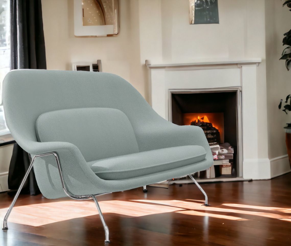 Heller Womb Sessel von Knoll International mit Chromgestell vor Kamin und Fenster.