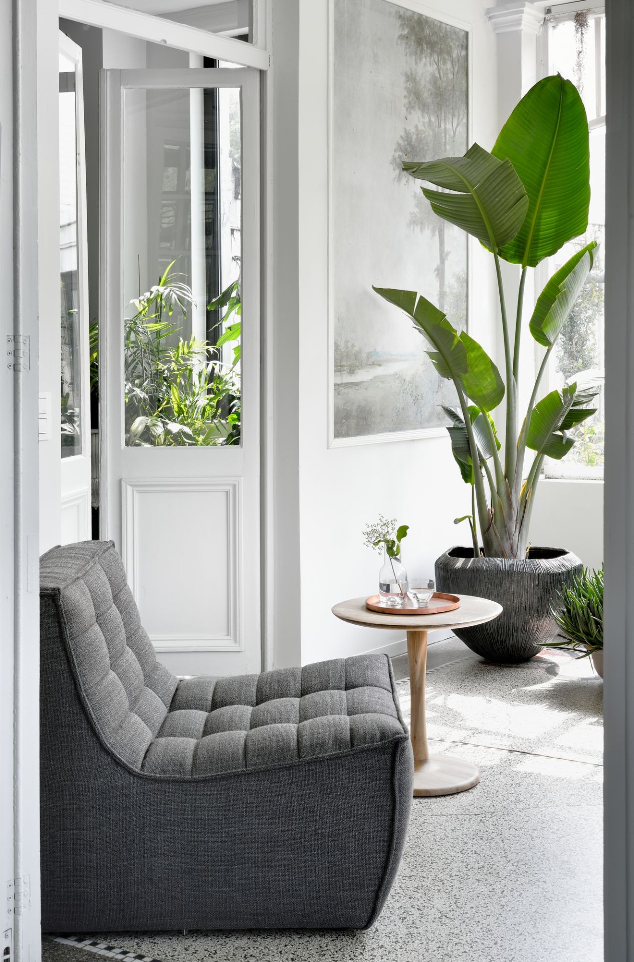 Grauer Sessel N701 von Ethnicraft mit gesteppter Oberfläche in einem hellen, modernen Wohnraum.