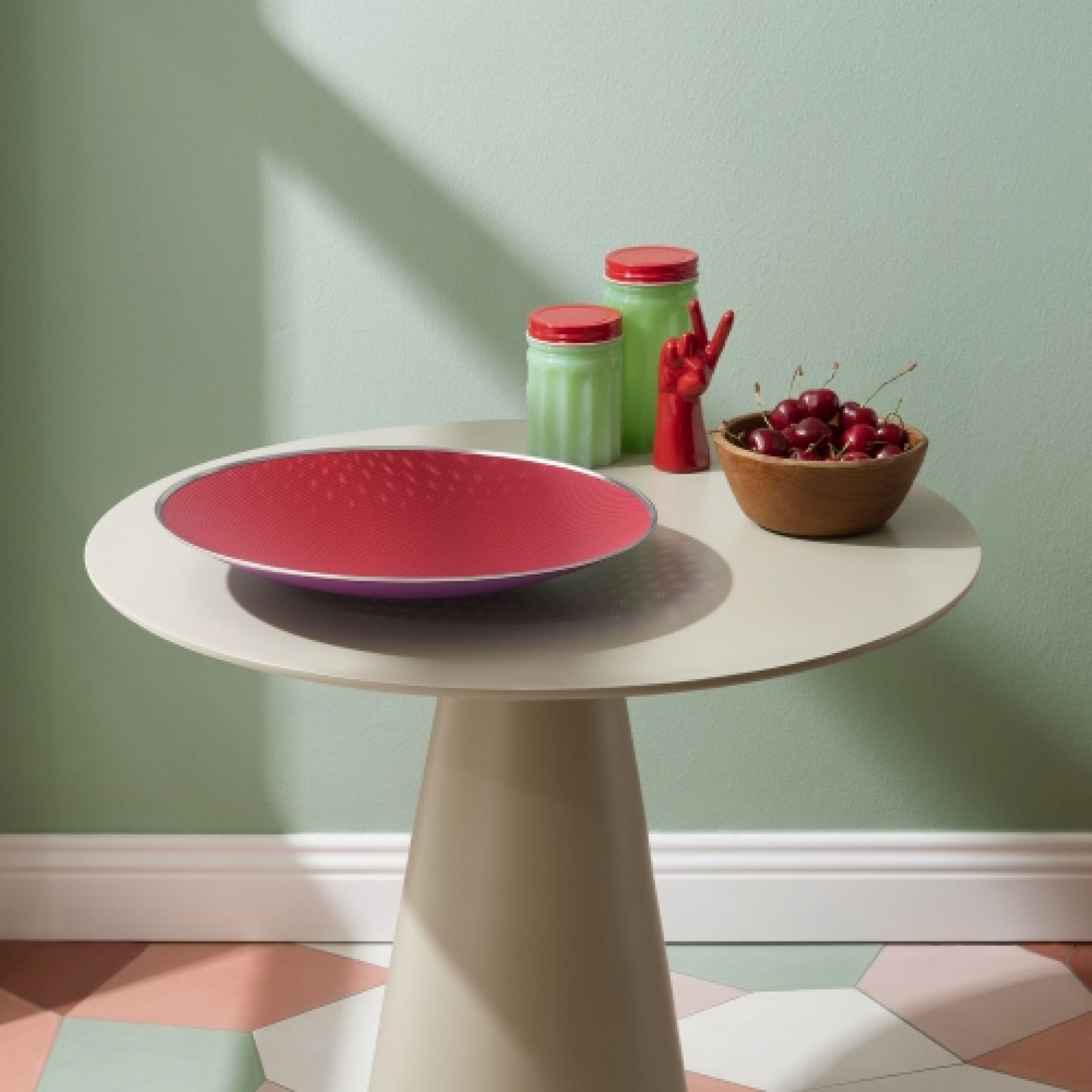 Cohncave Schale von Alessi, rot-violette Designschale auf einem Tisch, dekorative Obstschale.