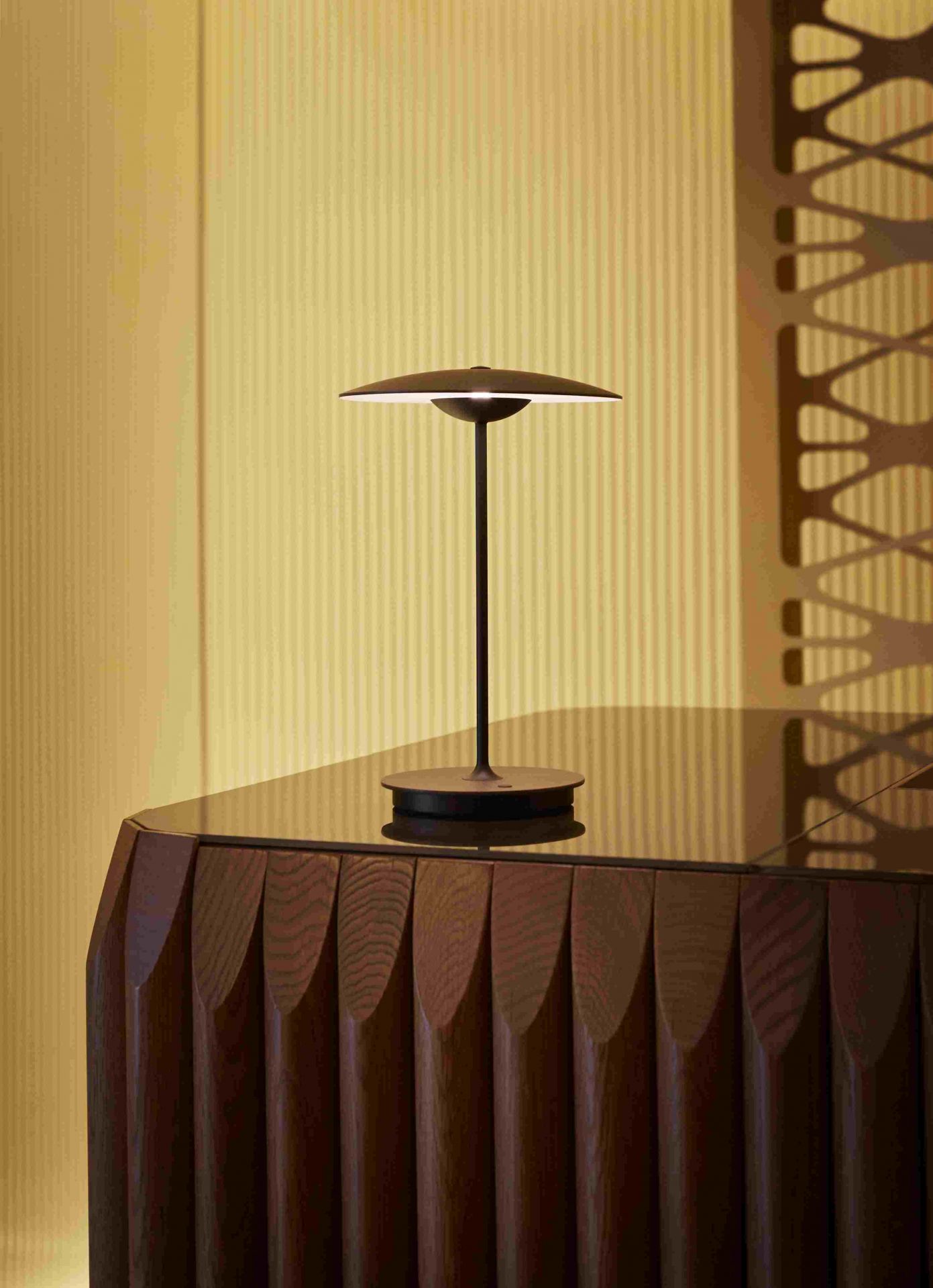 Ginger 20 M LED Akkuleuchte von Marset in Eiche auf einem Tisch.