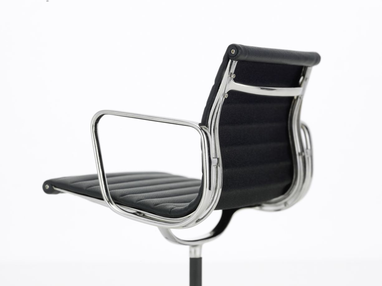 Detailaufnahme: MINIATUR Aluminium Chair Drehstuhl mit schwarzem Lederbezug und verchromtem Gestell.