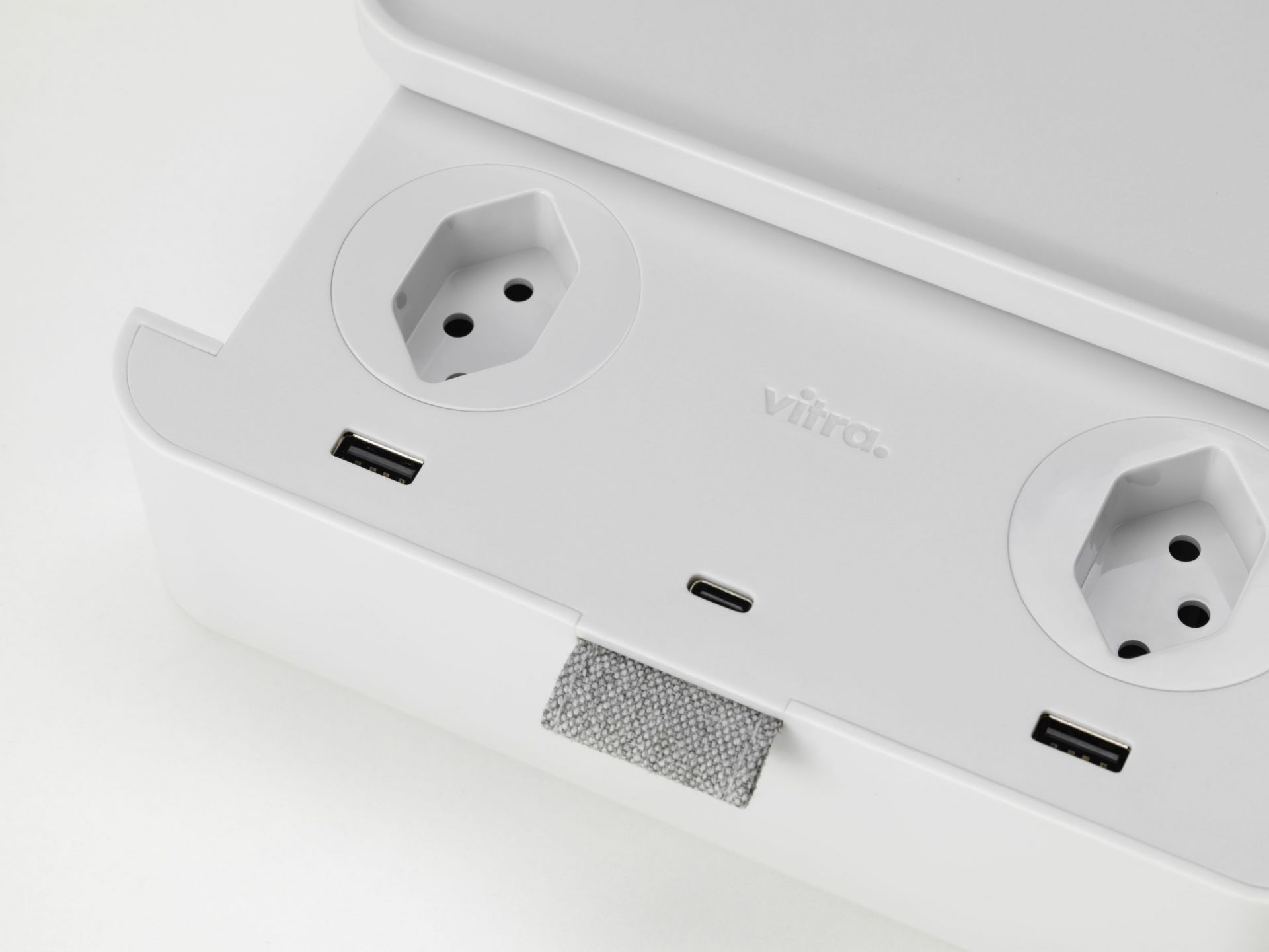 Weiße Vitra Ampi Mehrfachsteckdose mit USB-Anschlüssen und kabelloser Ladefunktion für Smartphones und andere Geräte.