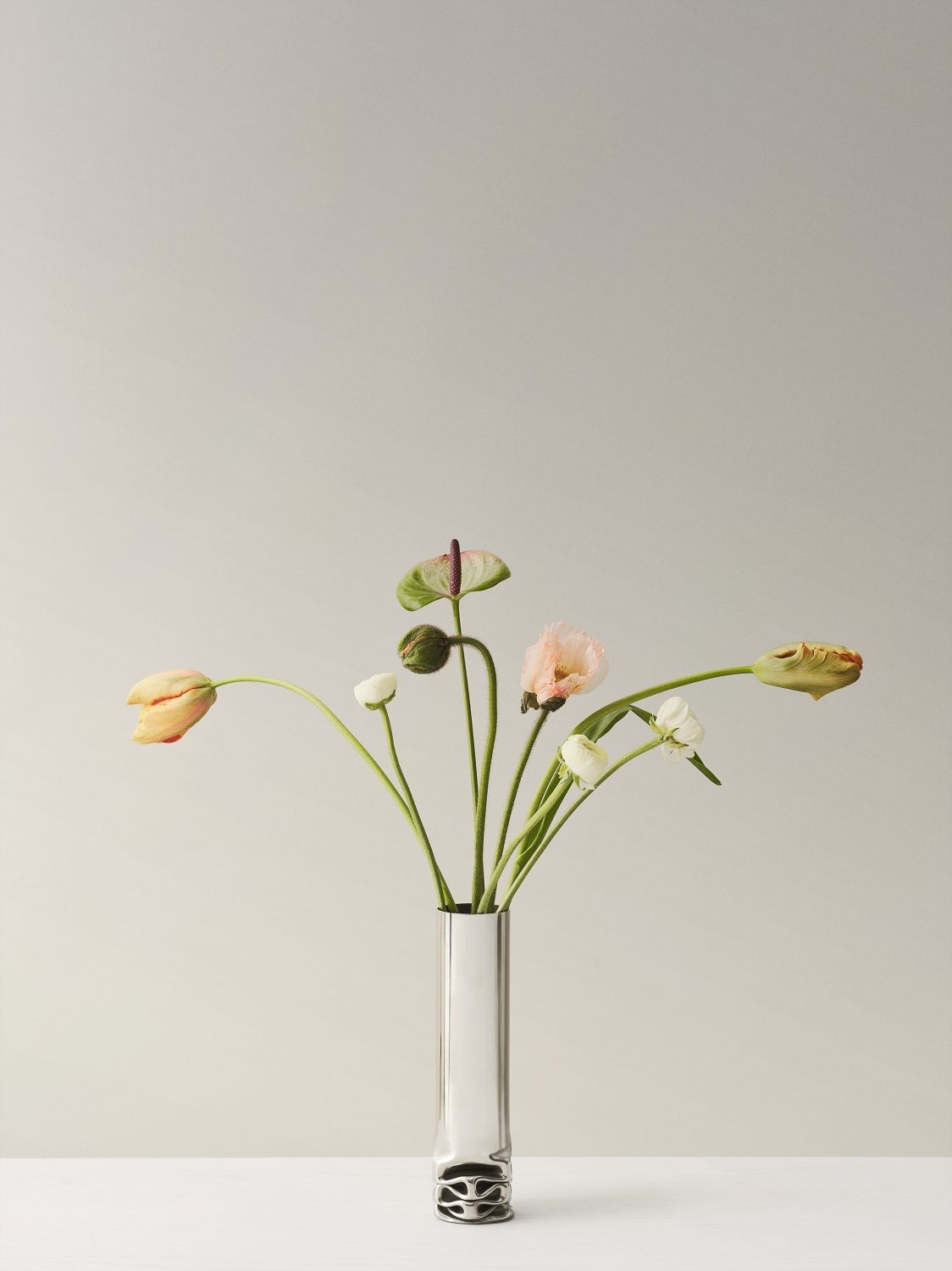 Hydraulic Vase von Design House Stockholm: Silberne Design-Vase mit zarten Blumen auf hellem Hintergrund.