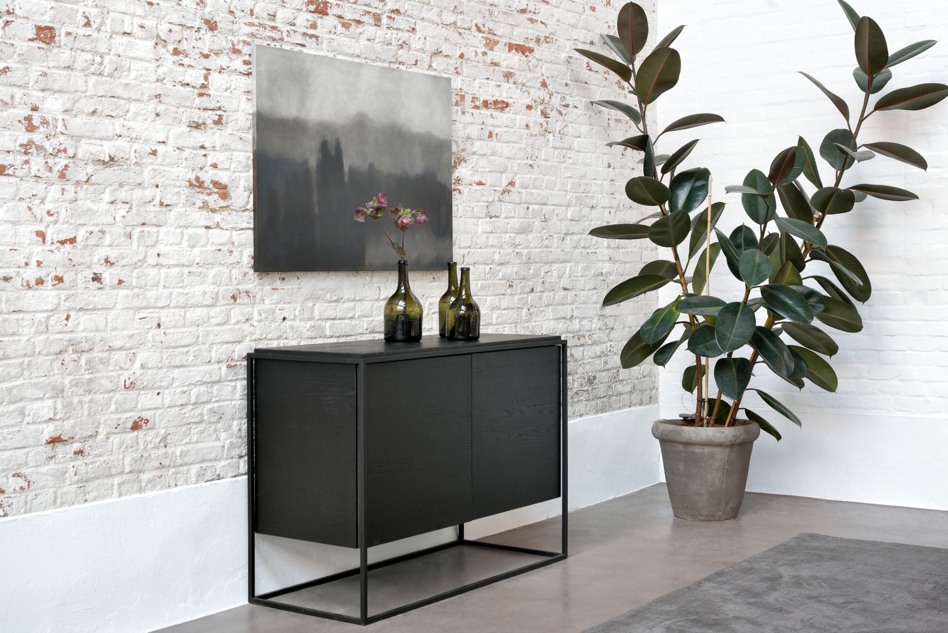 Monolit Sideboard von Ethnicraft: Schwarzes Sideboard aus Eiche mit minimalistischem Gestell im modernen Wohnzimmer.