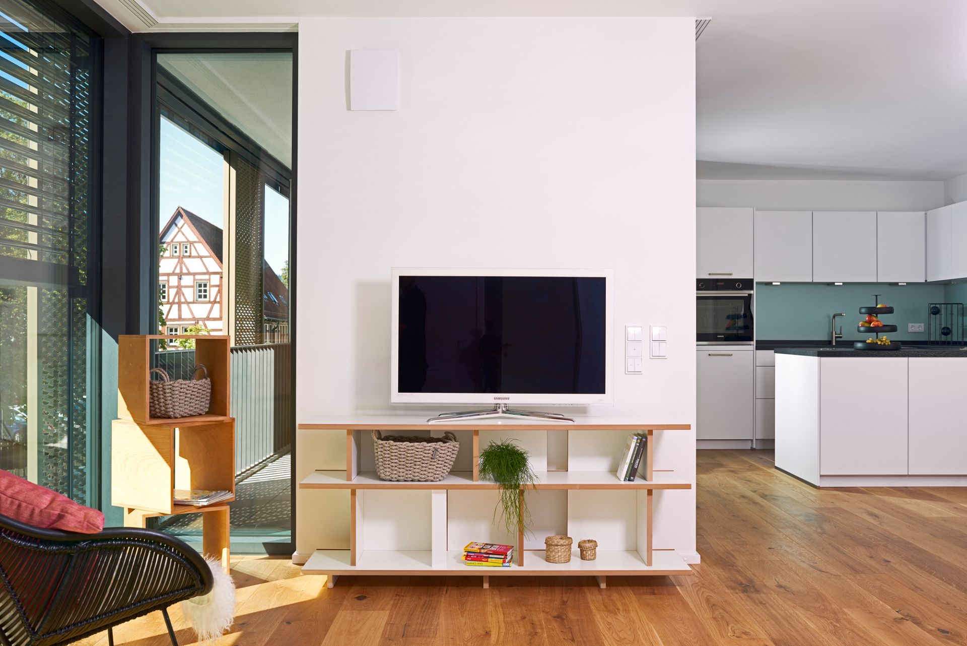 Helles Wohnzimmer mit niedrigem Tojo Regal Anbaumodul als TV-Möbel und Stauraum.