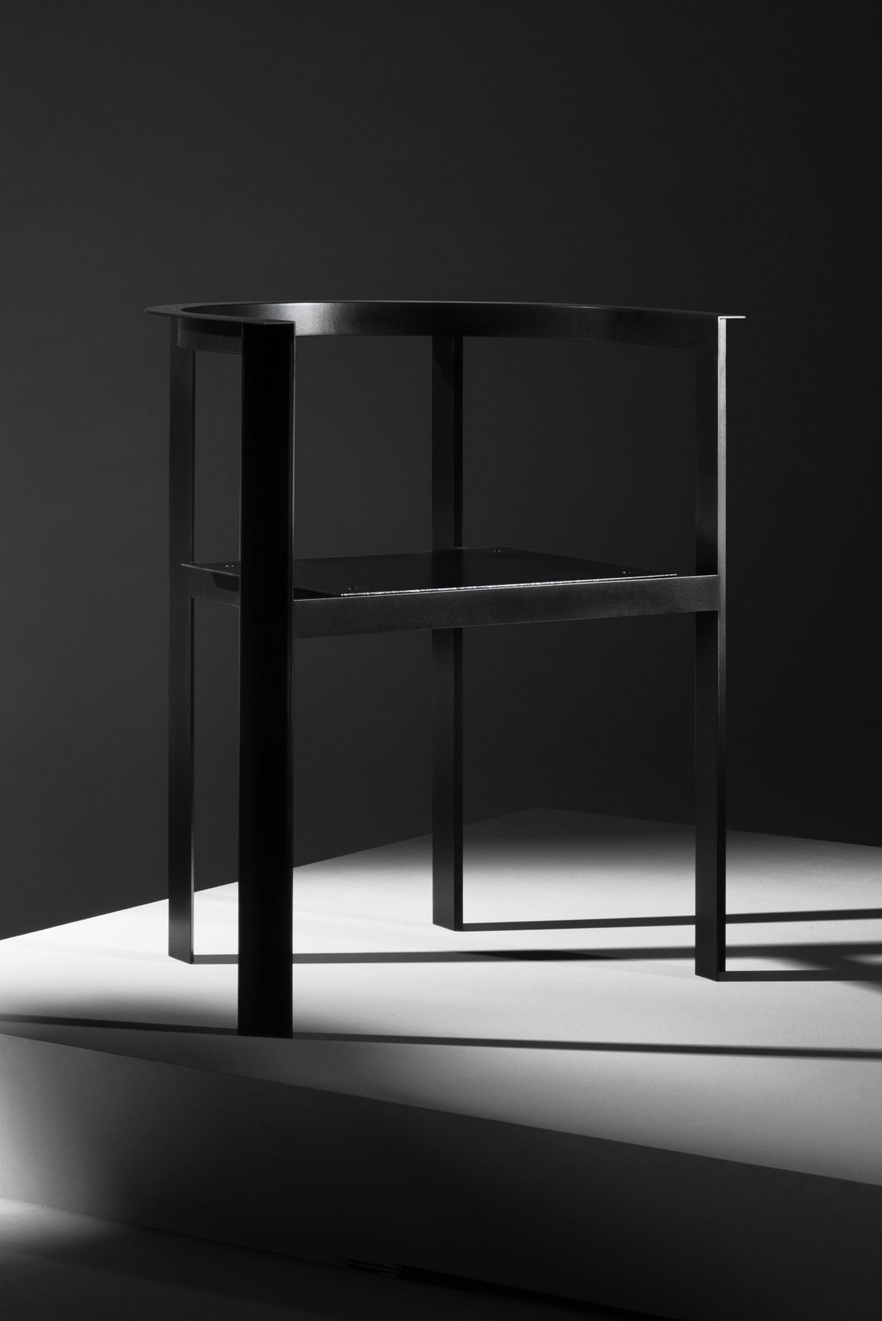 Schwarzer Throne Stuhl von New Tendency, minimalistisches Designmöbel mit zwei Ebenen und Schattenwurf.