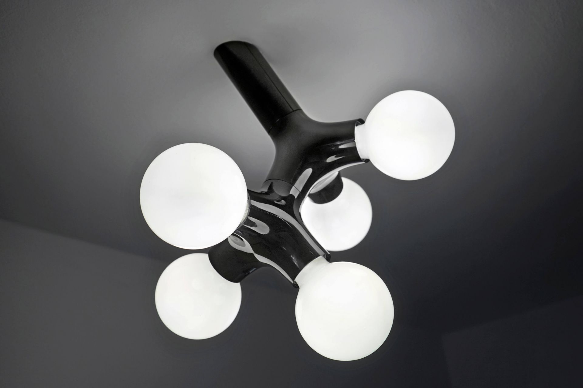 Schwarze DNA Wandleuchte mit fünf runden, weißen Leuchtkörpern. Moderne Deckenleuchte für Wohnzimmer und Schlafzimmer.