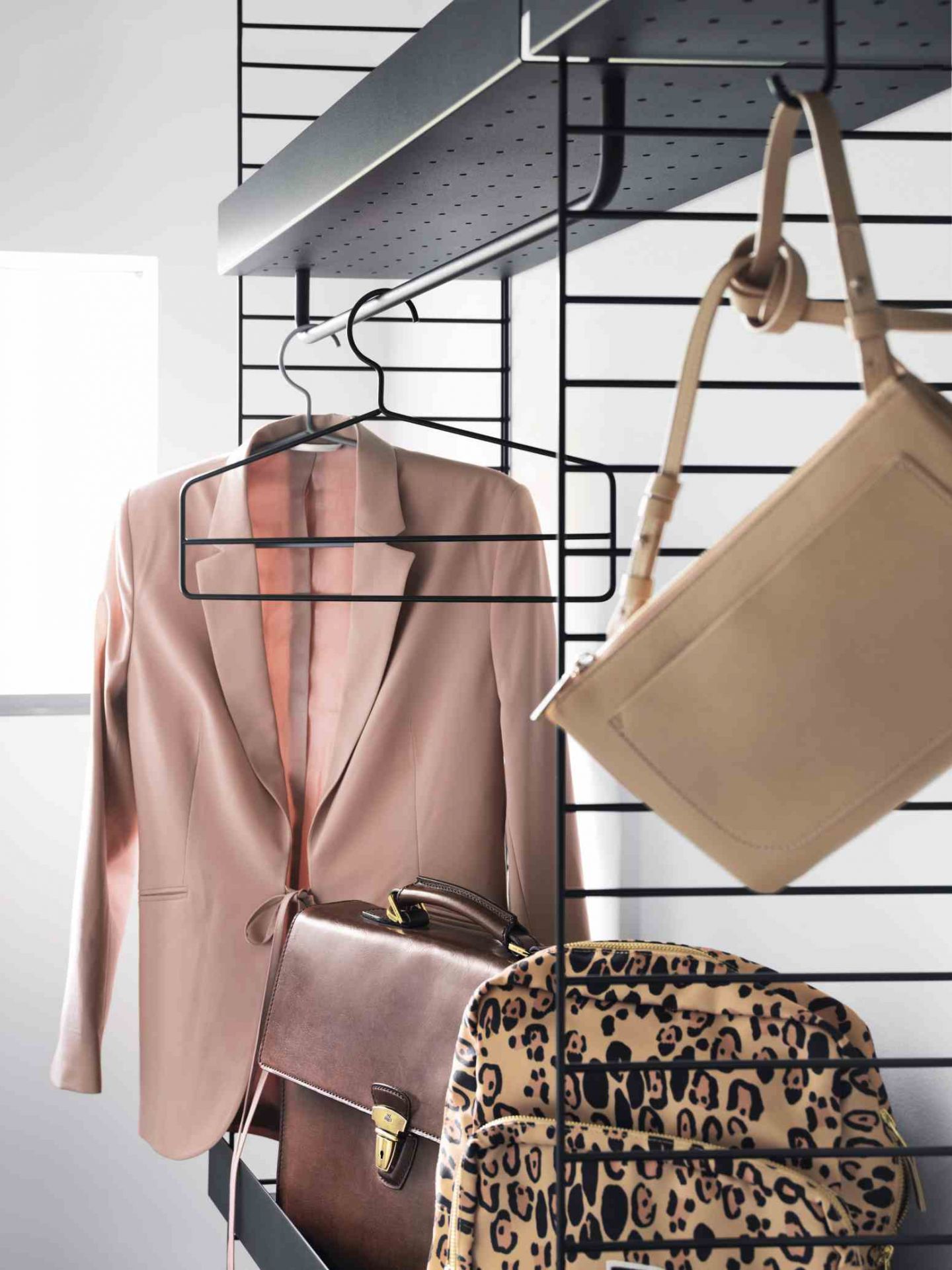 String Regalsystem mit Kleidung und Taschen. Bodenstehendes Regal von String Furniture.