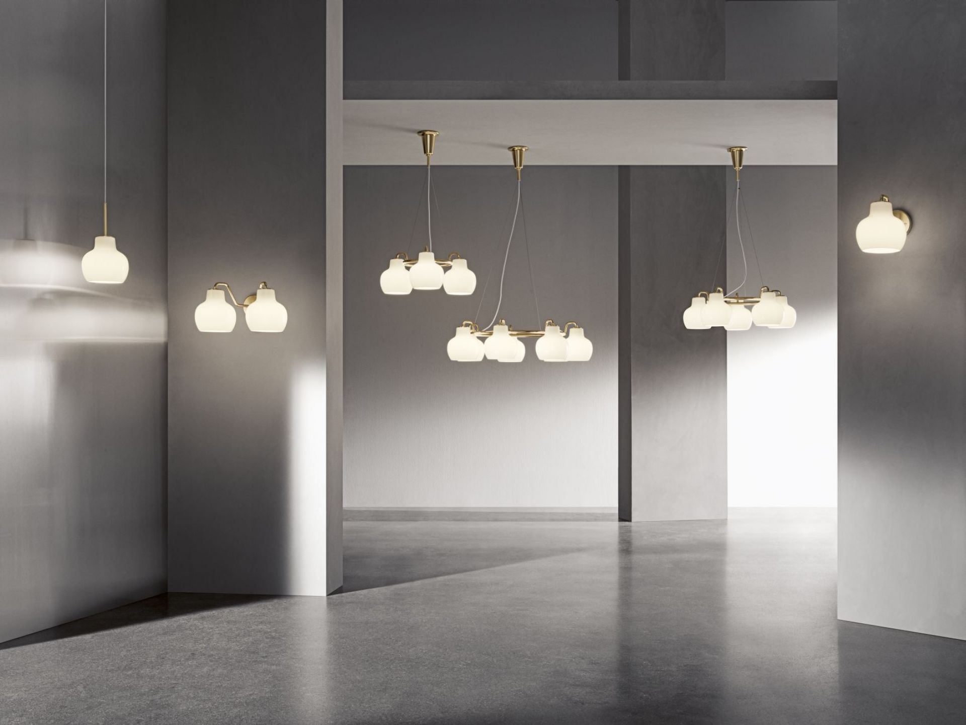 Innenaufnahme mit verschiedenen VL Ring Crown Lampen von Louis Poulsen: Wandleuchte, Pendelleuchte mit Messingdetails und Opalglas.