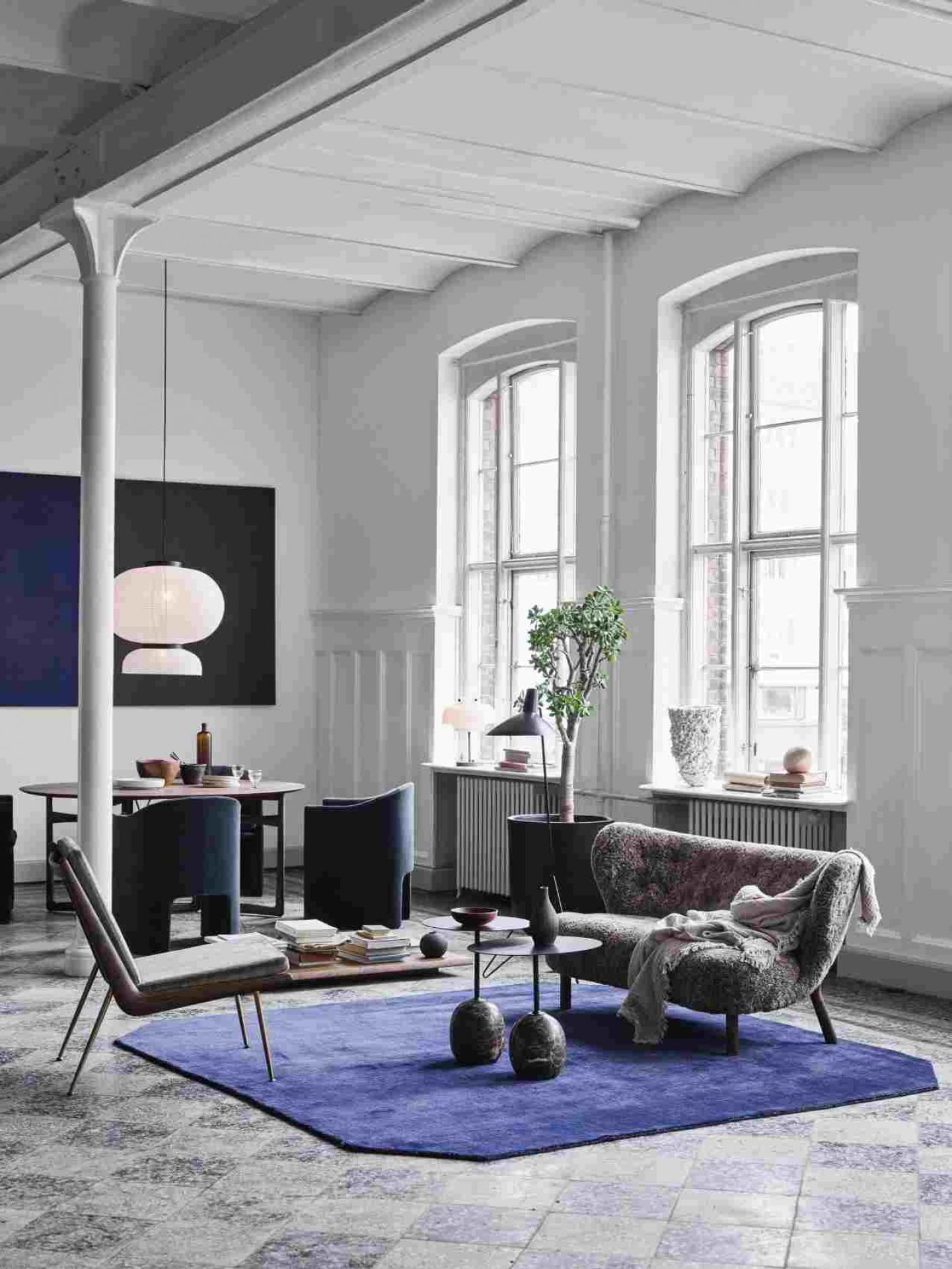 AndTradition Boomerang Lounge Chair HM1 Sessel in stilvollem Wohnzimmer mit Teppich und Designermöbeln.