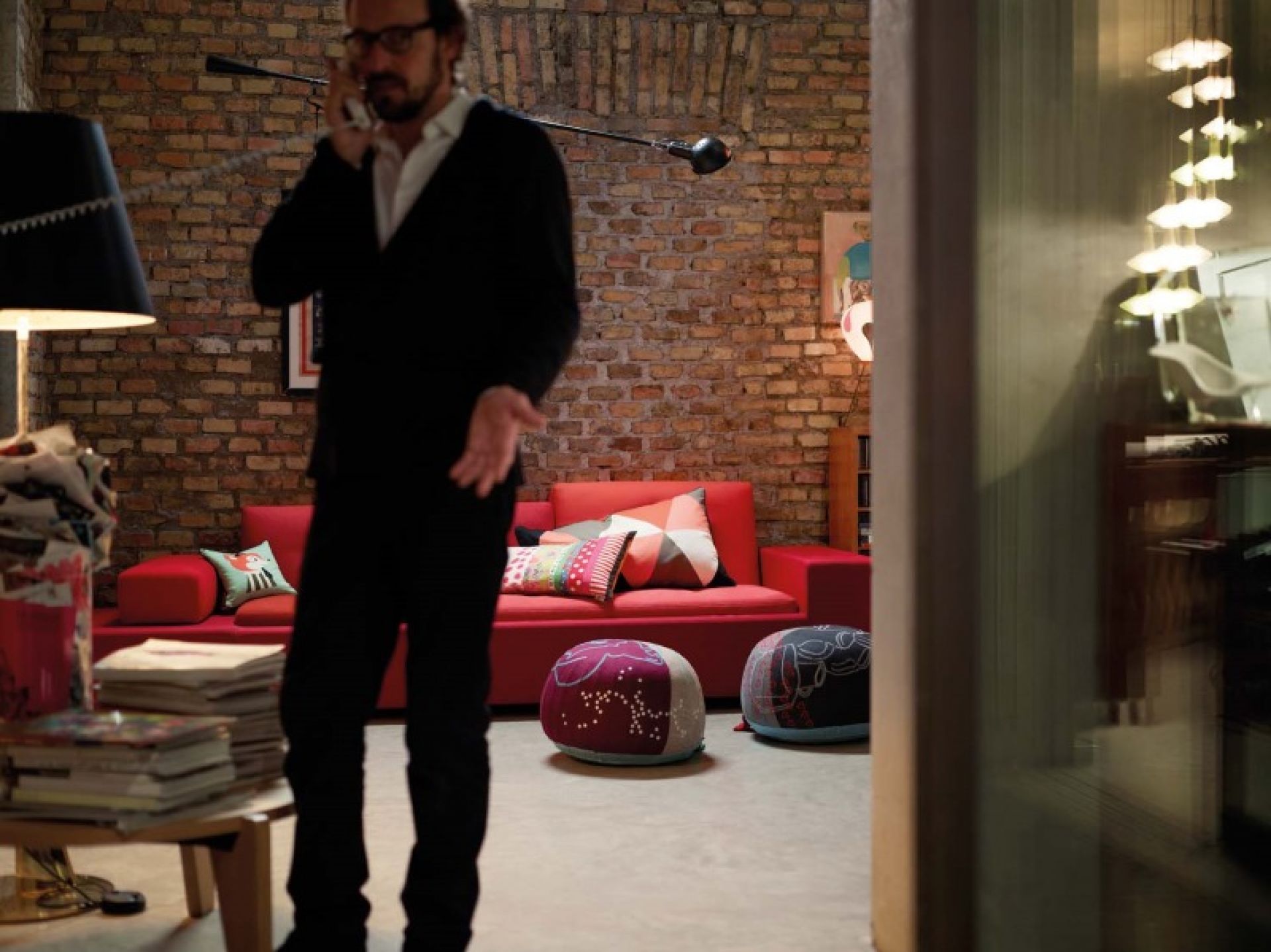 Wohnzimmer mit rotem Sofa, Poufs und einem Gueridon Beistelltisch von Vitra im Vordergrund.