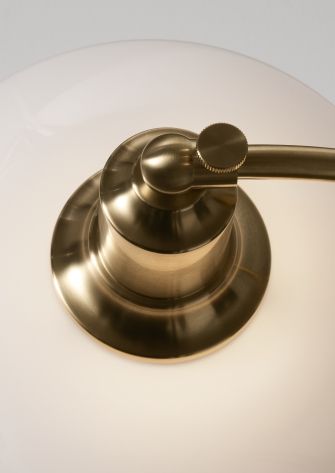 Detailaufnahme: PH 2/2 Luna Tischleuchte von Louis Poulsen mit Messingfuß und Opalglasschirm.