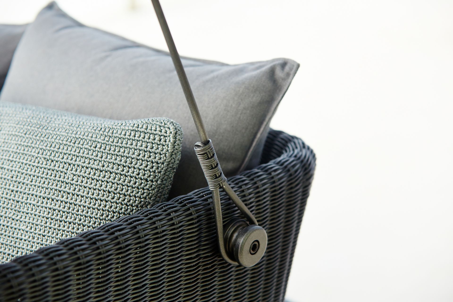 Detailaufnahme: Cane-Line Cave Gartenschaukel mit Kissensatz, schwarzes Rattan, graue Kissen.