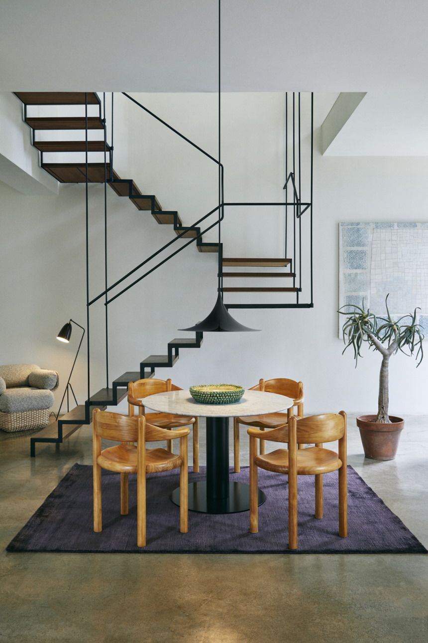 Esszimmer mit Gubi Semi Pendelleuchte in Dunkelkakao glänzend über rundem Tisch.