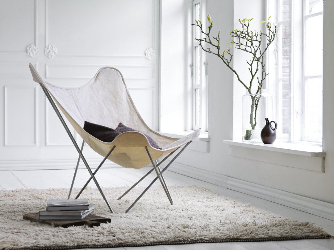 Canvas Mariposa Sessel mit hellem Bezug und Kissen, ein moderner Butterfly Chair für Wohnzimmer.