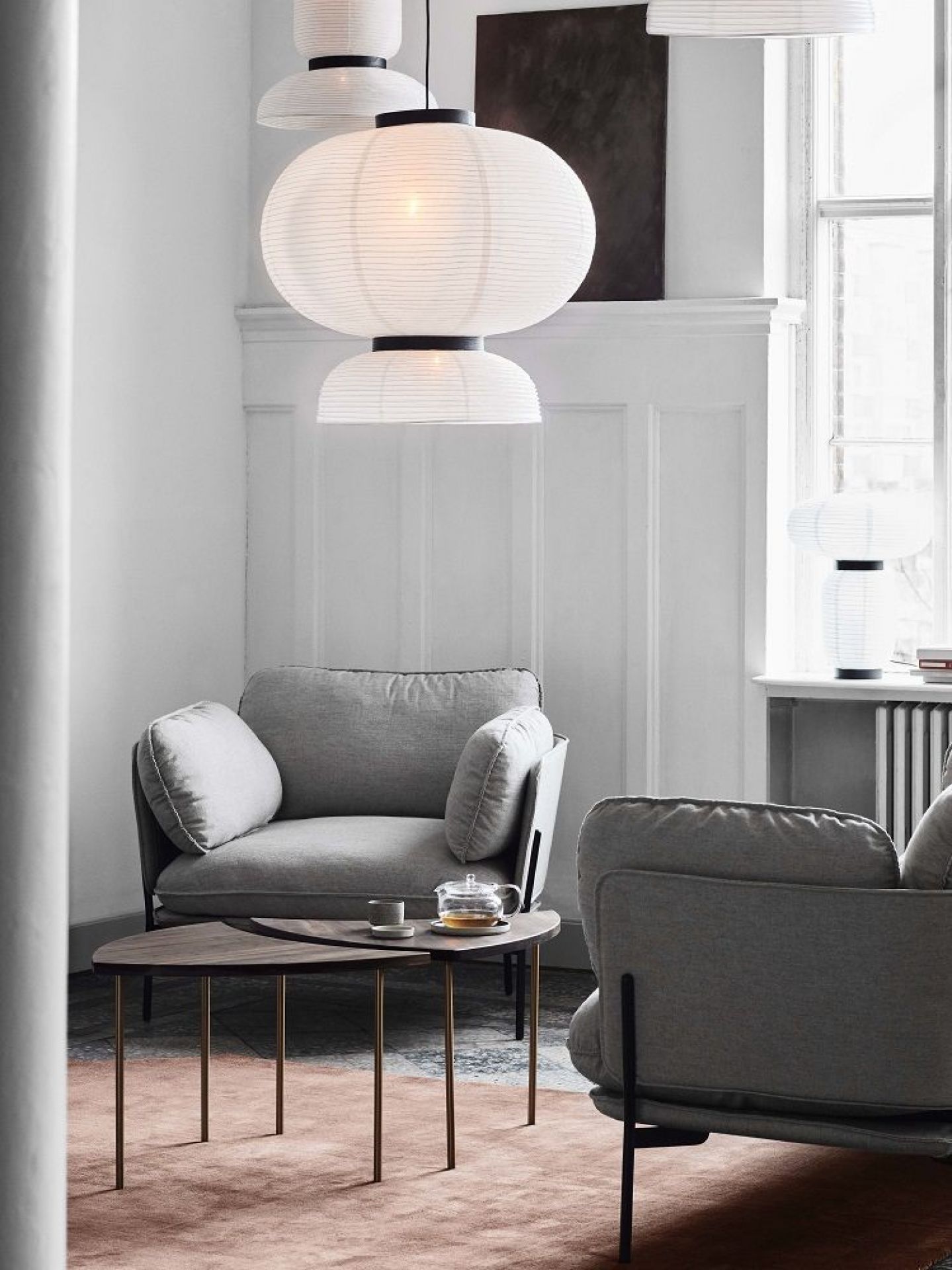 AndTradition Pinwheel HM7 Beistelltisch aus Holz und Metall im modernen Wohnzimmer mit Sesseln.