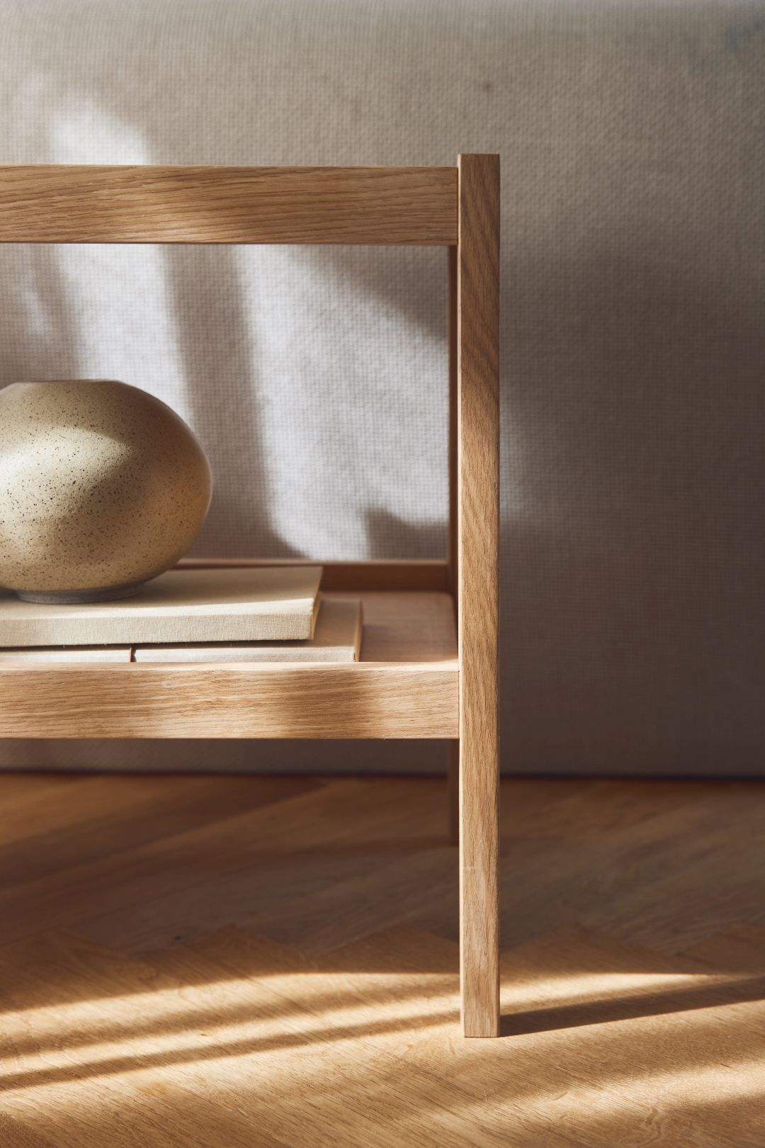 Detailaufnahme des Form & Refine Journal Beistelltisches aus Eiche mit Deko-Objekten.