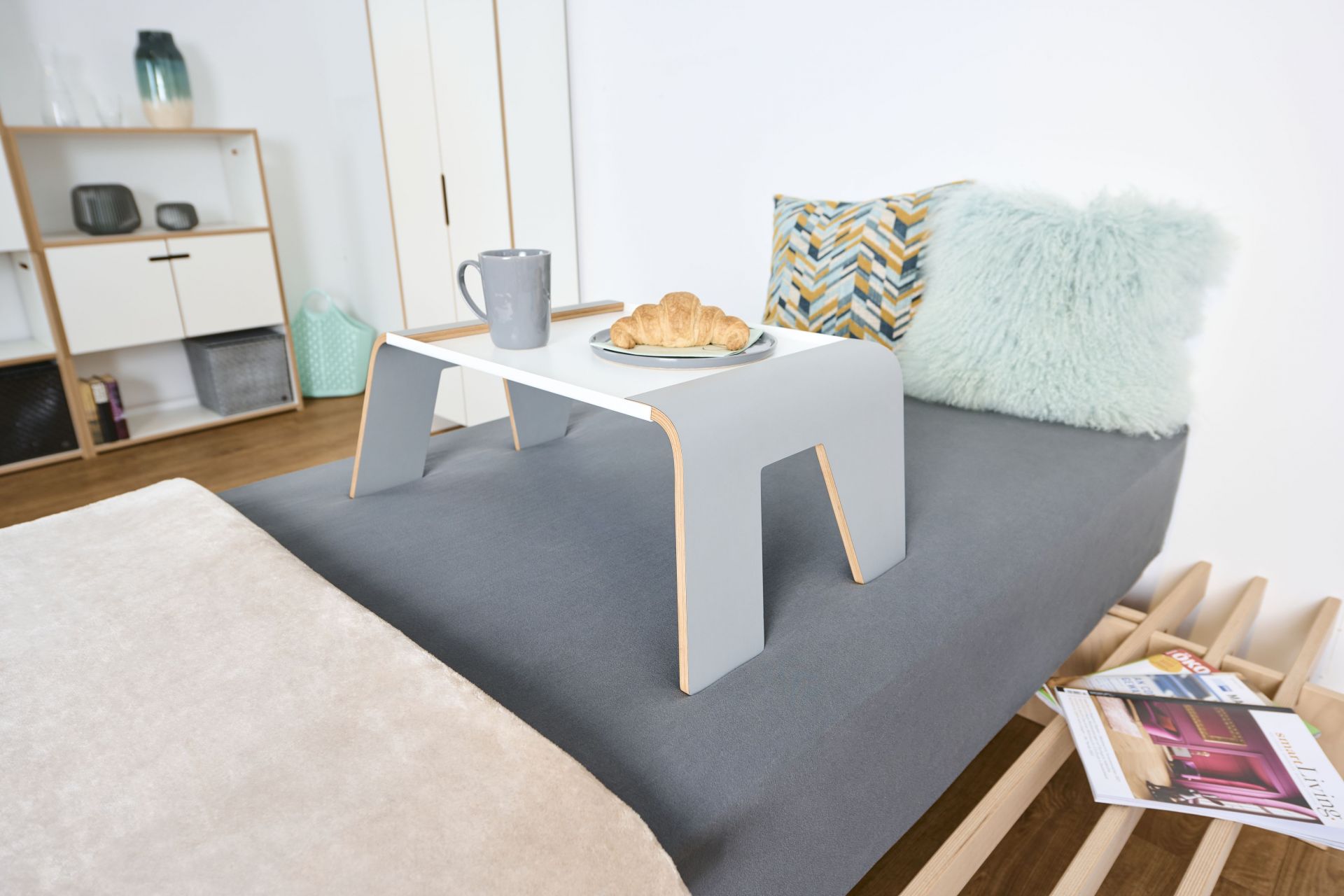 Tojo Tablett auf Bett mit Tasse und Croissant. Praktischer Notebooktisch für Bett und Sofa.