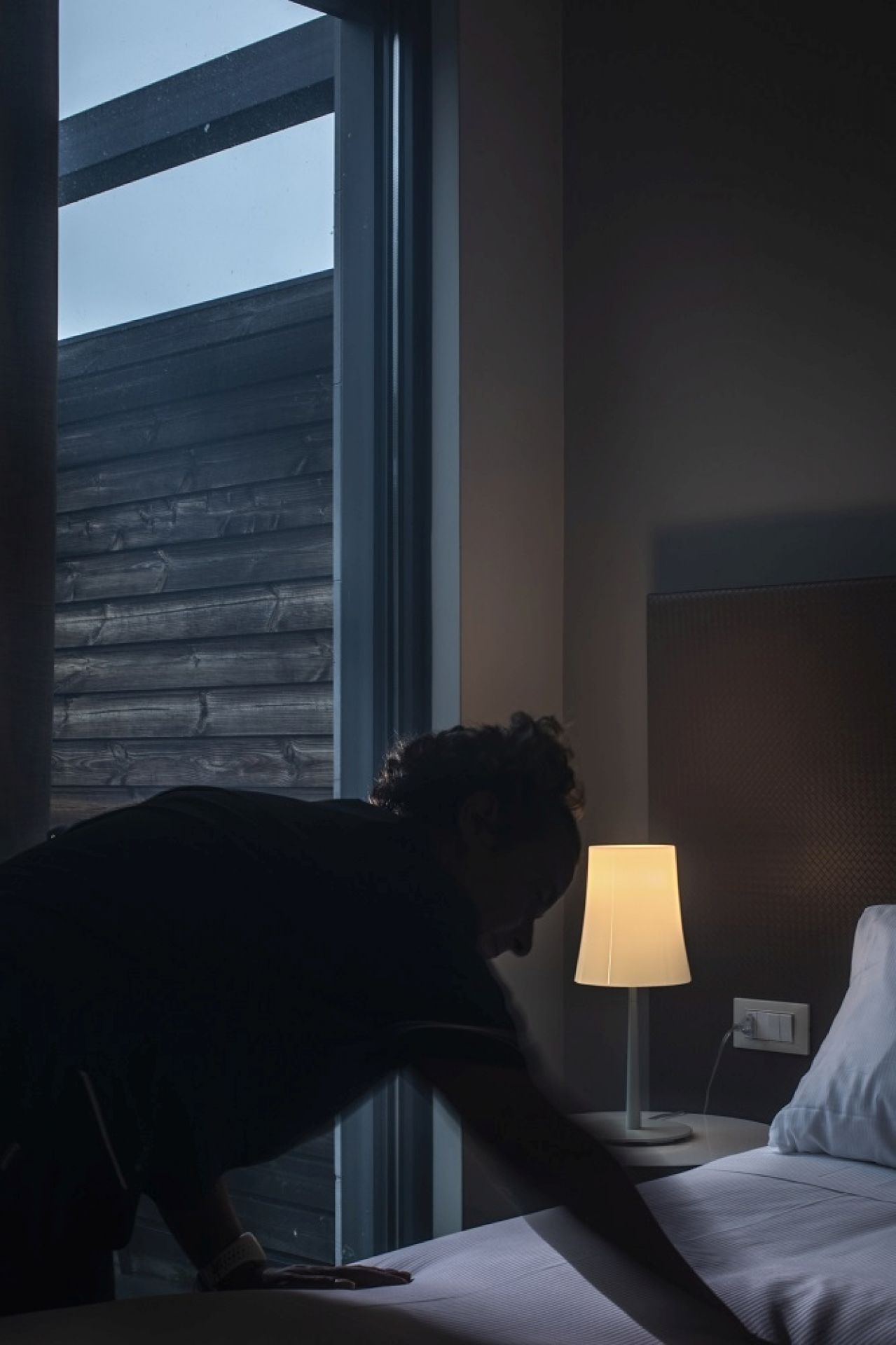 Birdie Easy Tavolo Tischleuchte von Foscarini in Weiß neben einem Bett. Moderne Tischlampe.