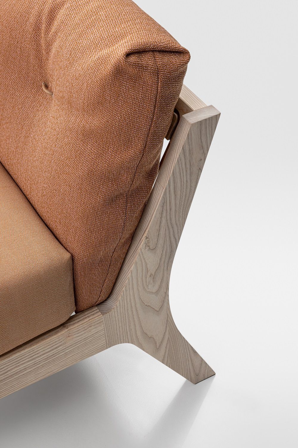 Detailaufnahme Mellow Bett: Massivholzrahmen mit orangefarbenem Kissen, modernes Design Schlafzimmermöbel.