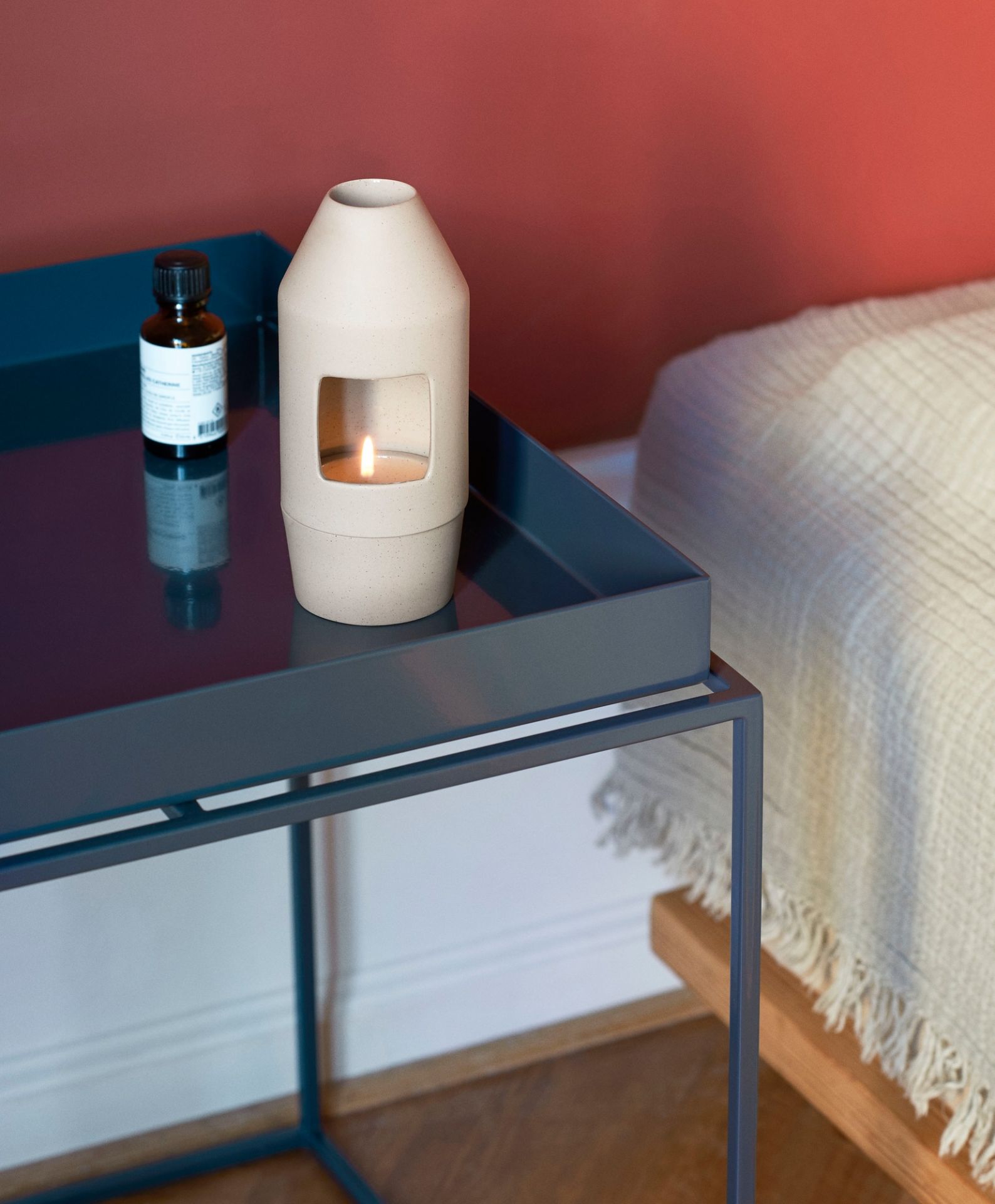 Chim Chim Duftdiffusor von Hay, hell beiges Porzellan, mit Duftöl auf einem Tisch.