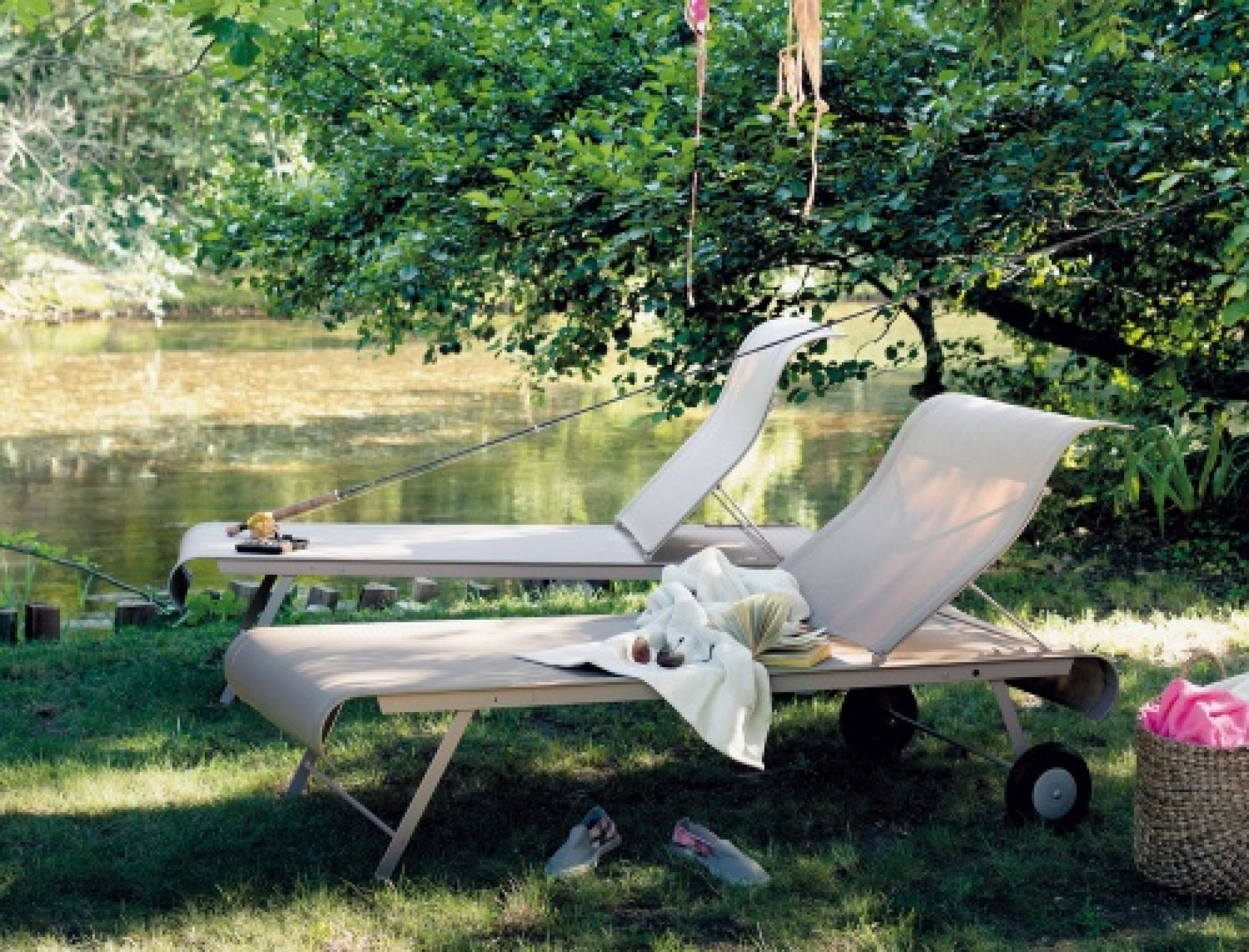 Dune Sonnenliege von Fermob im Freien am See, ideal zum Entspannen und Sonnenbaden.