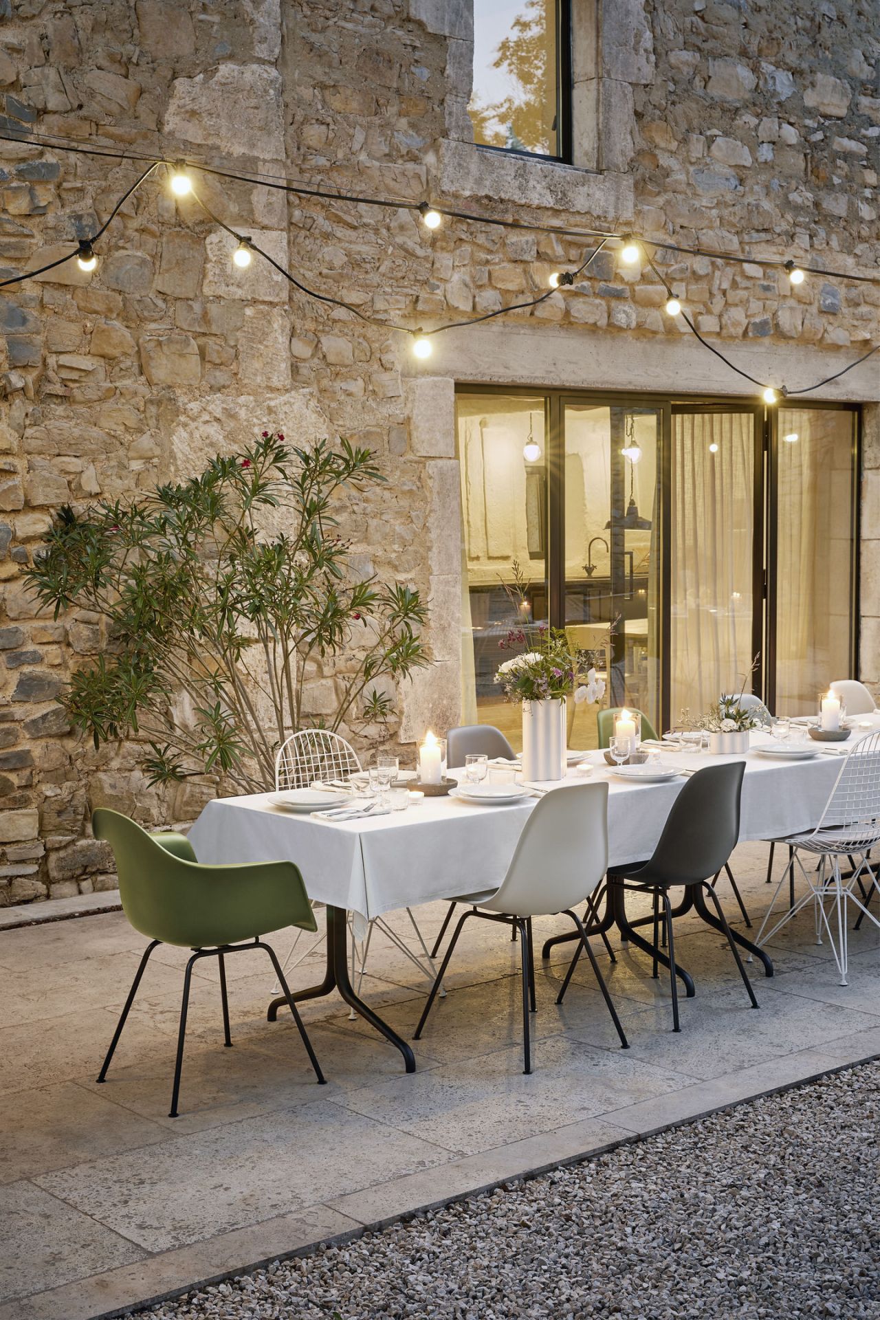 Esstisch im Freien mit Vitra Eames Plastic Arm Chairs DAX und Sitzpolster.