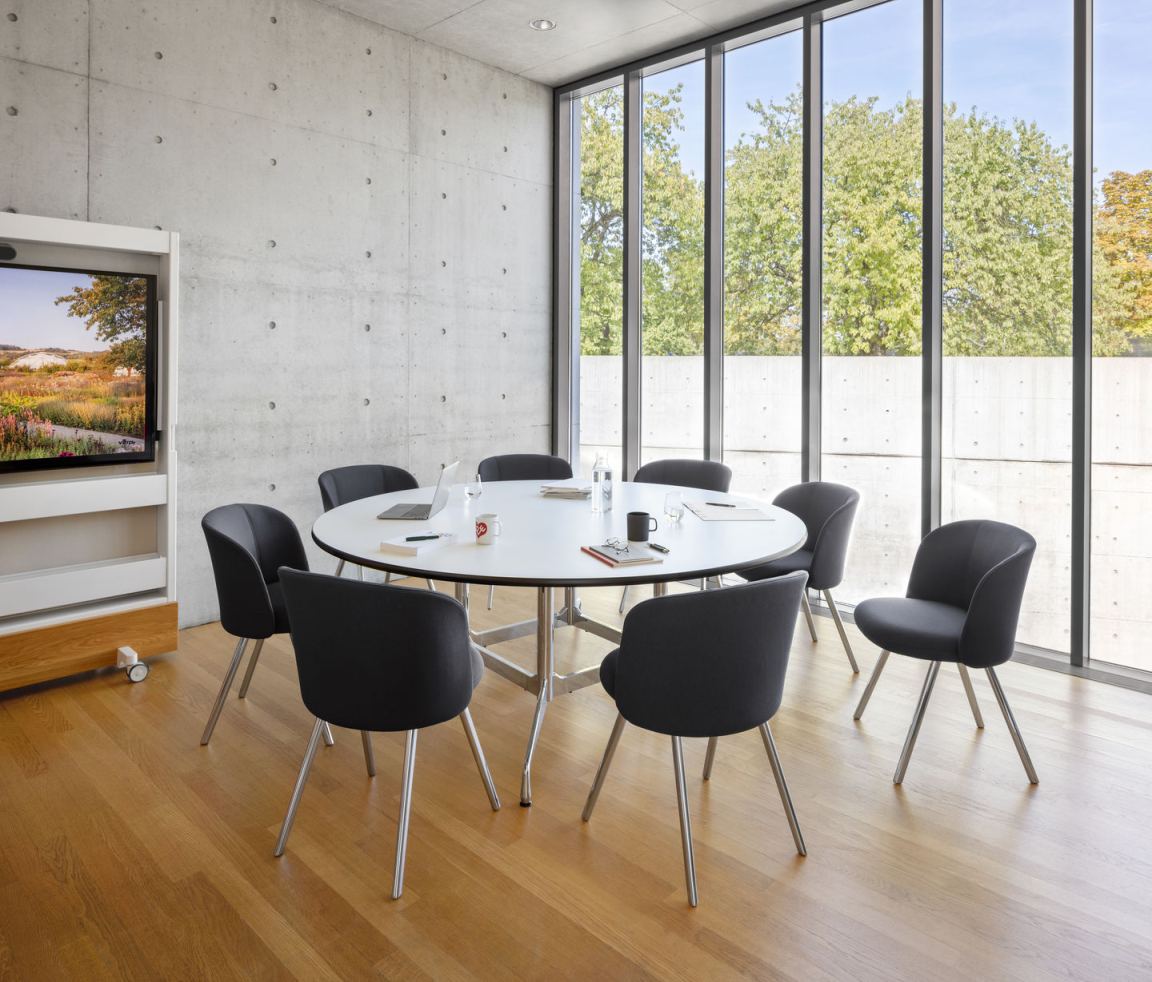 Besprechungsraum mit mehreren grauen Mikado Side Chairs von Vitra um einen runden Tisch.