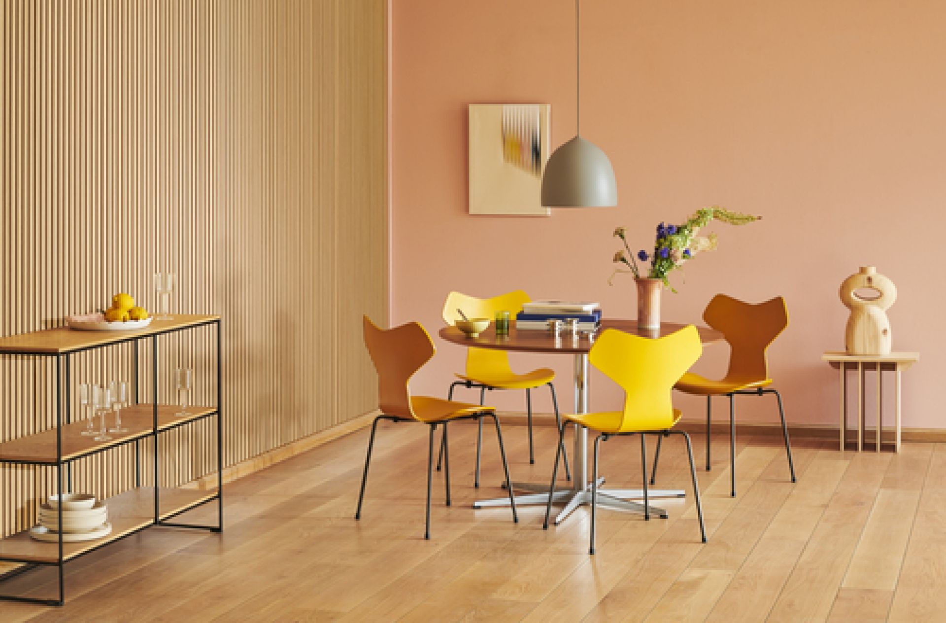Helles Esszimmer mit Fritz Hansen Planner Shelving Regal, Tisch, Stühlen und Dekoration.