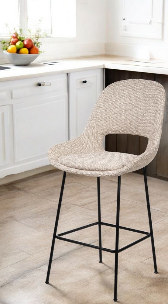 Theia Counter Armchair Low Barhocker von Freifrau Manufaktur mit beigem Stoffbezug und schwarzem Metallgestell.