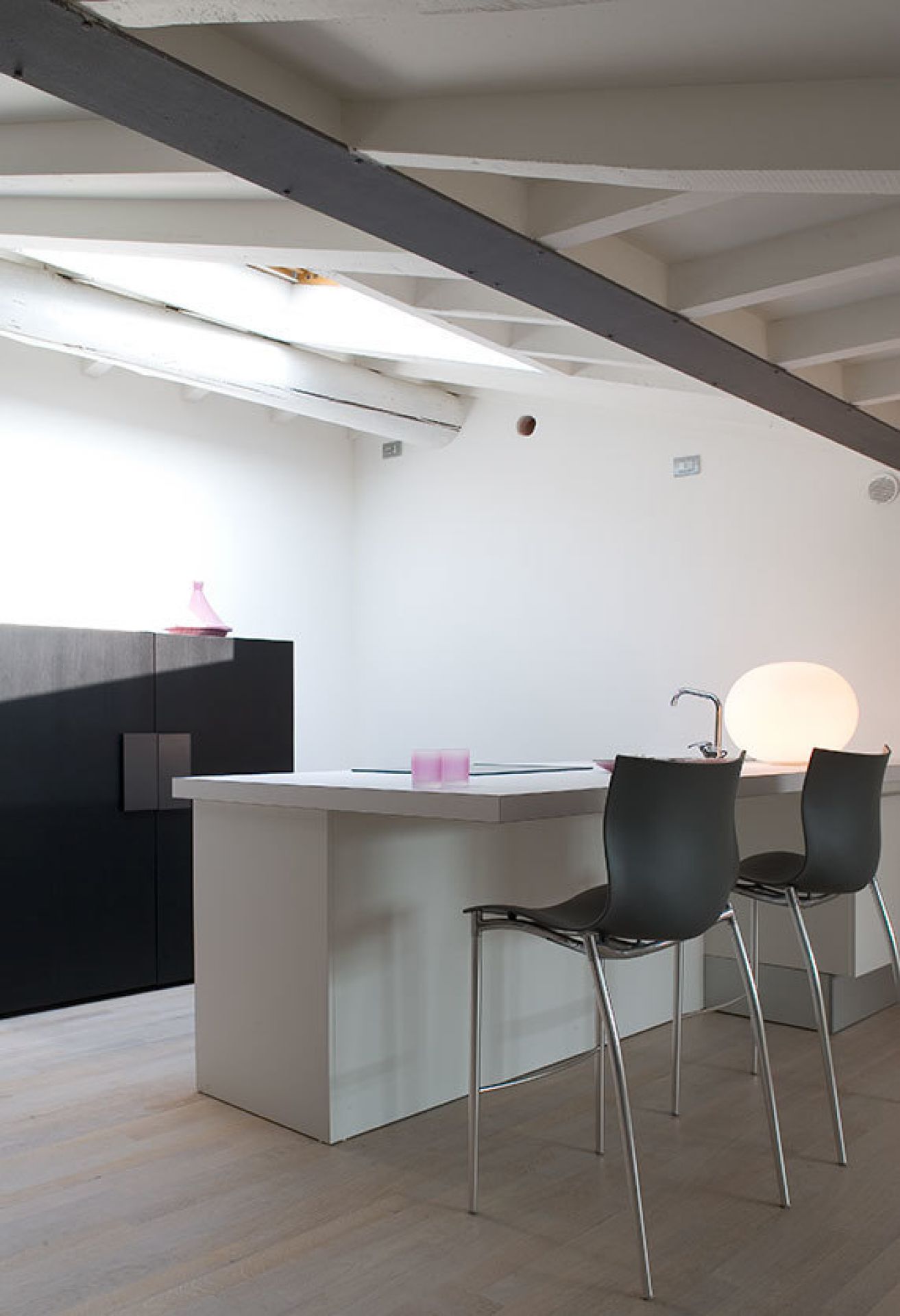 Glo Ball Tischleuchte von Flos auf Küchentheke, modernes Design, stimmungsvolle Beleuchtung.