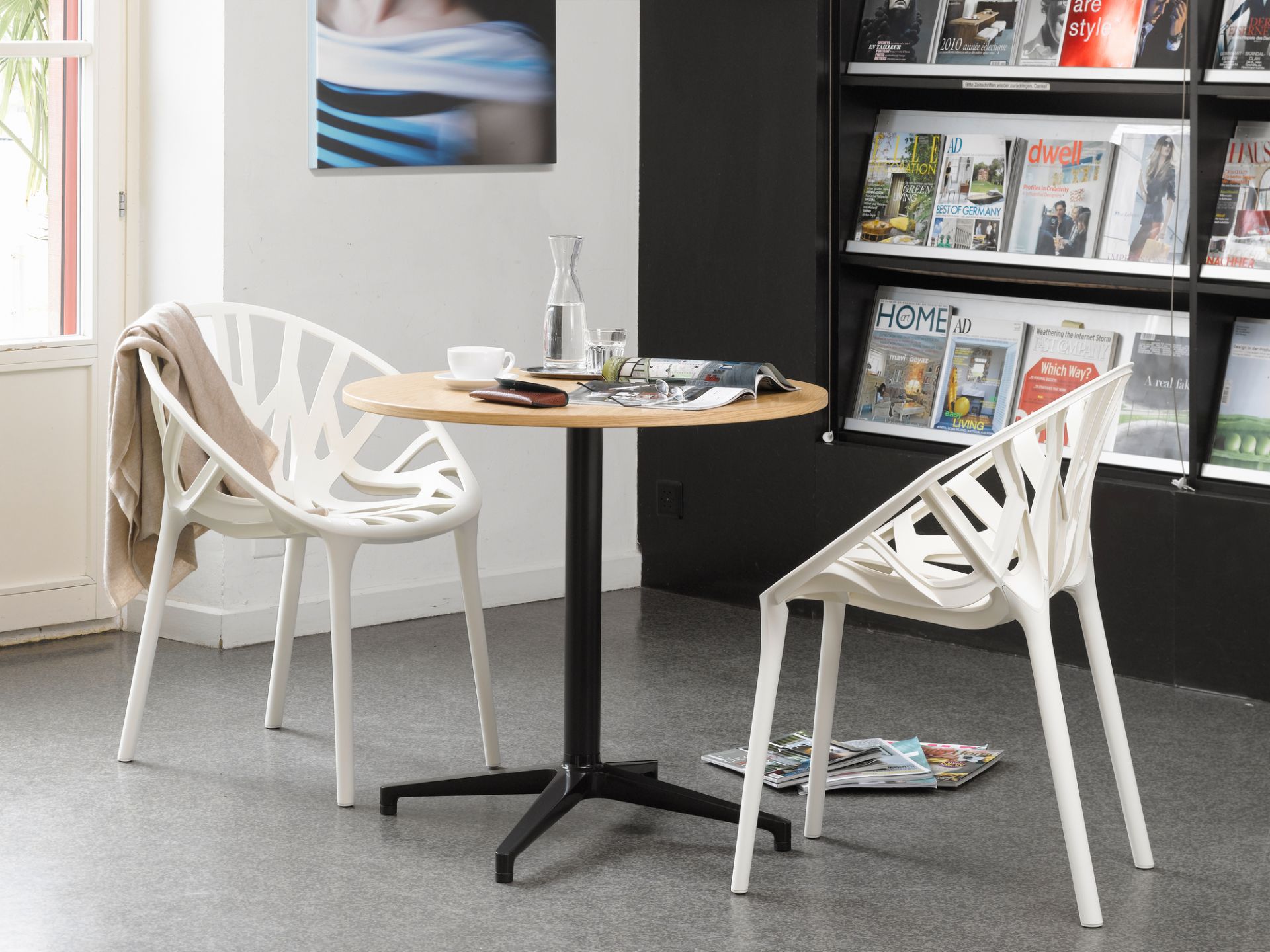 Runder Bistro Table Tisch von Vitra mit zwei weißen Stühlen im Innenbereich.