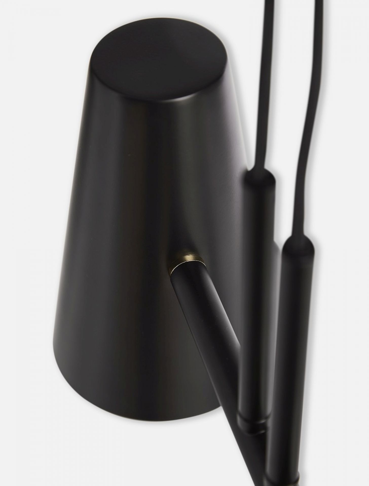 Detailaufnahme der schwarzen Cono Pendelleuchte von Woud mit zwei Lampenschirmen und Kabeln.