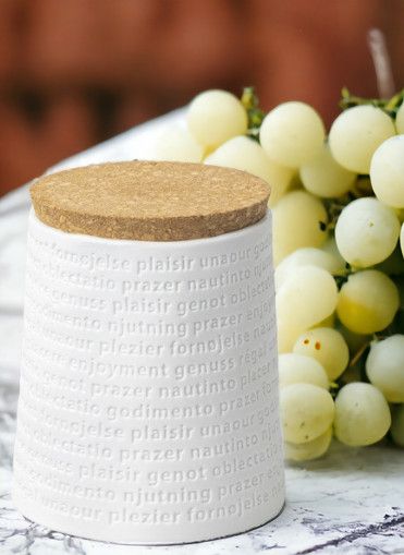 Raumpoesie Vorratsdose mit Korkdeckel, weiße Keramikdose mit "Genuss" Schriftzug, neben grünen Trauben.