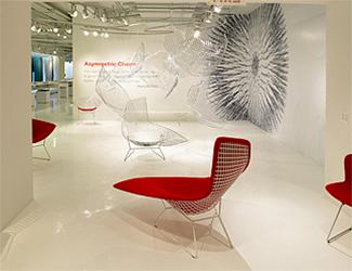 Roter Bertoia Liegesessel von Knoll International im Ausstellungsraum, Designklassiker mit Drahtgestell und Sitzpolster.