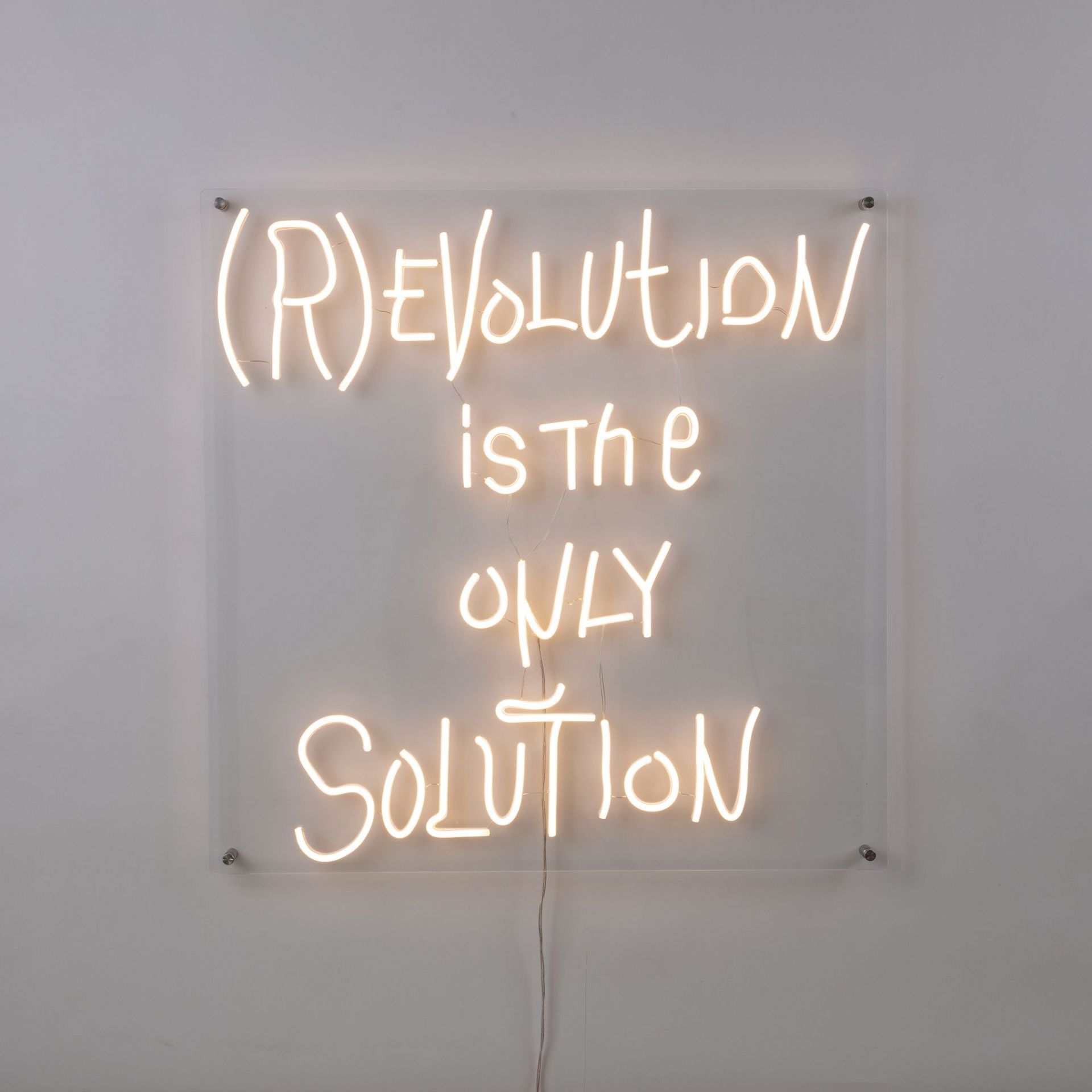 Revolution LED Wandleuchte Seletti: Neon-Schriftzug "(R)EVOLUTION is the ONLY SOLUTION" an der Wand.
