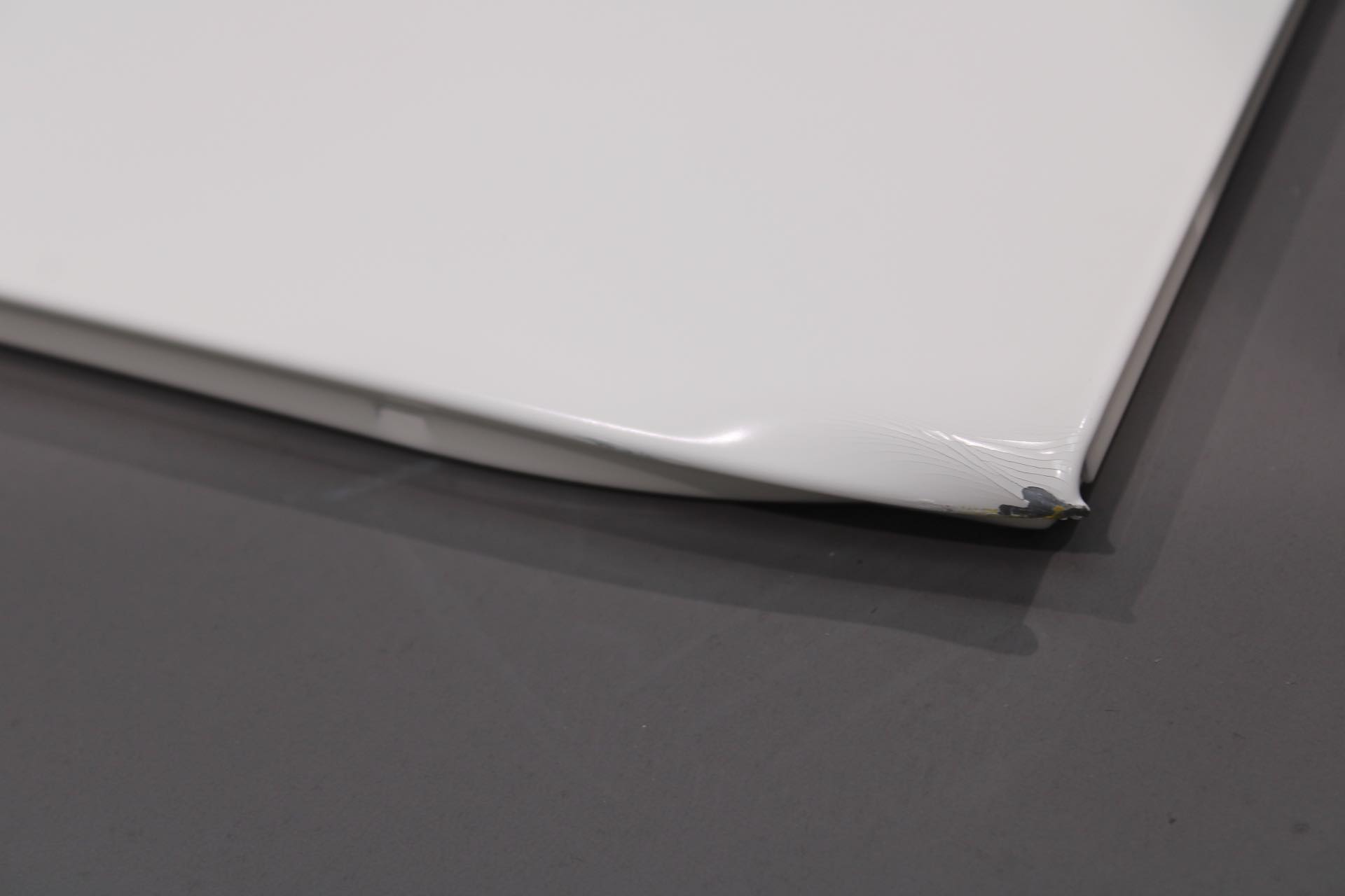 Detailaufnahme einer reinweißen USM Haller Klapptür (Mängelexemplar) mit Beschädigung an der Kante.