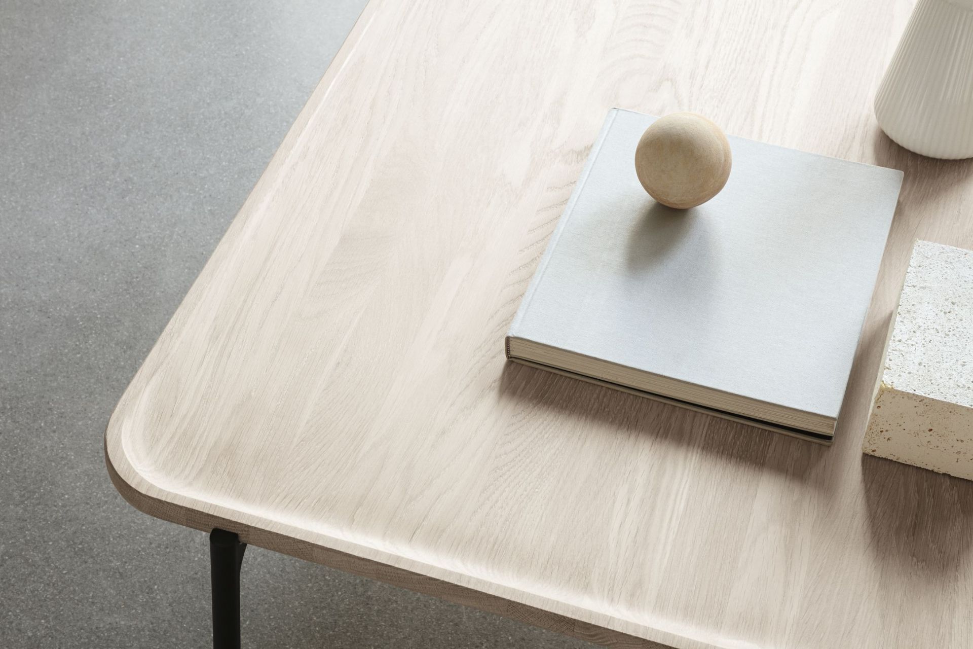 Detailansicht des Savoye Tisches von Eva Solo: Rechteckiger Couchtisch aus heller Eiche mit Buch und Dekoration.