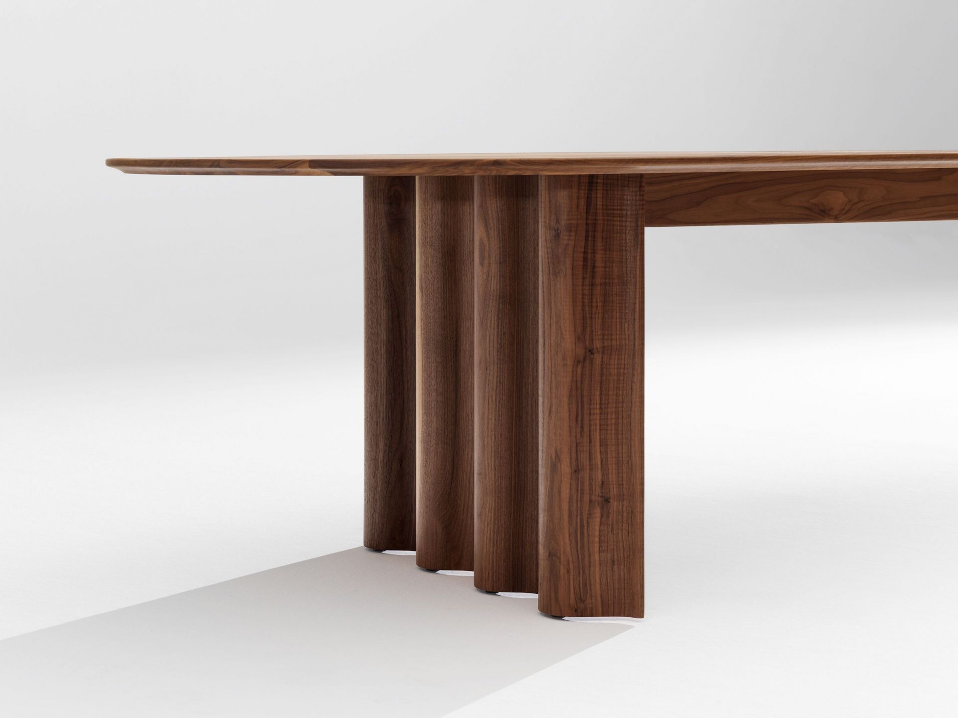 Detailaufnahme des Curtain Tisches: Rechteckiger Esstisch aus dunklem Holz mit einzigartigen, geriffelten Beinen.