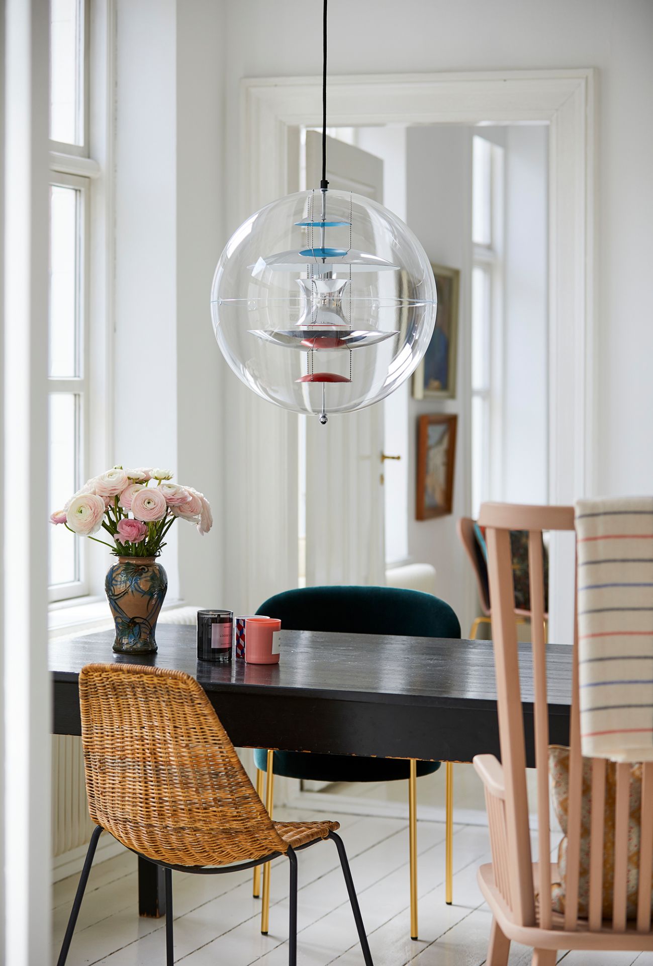 VP Globe Pendelleuchte von Verpan über Esstisch mit Stühlen und Blumenvase in hellem Raum.