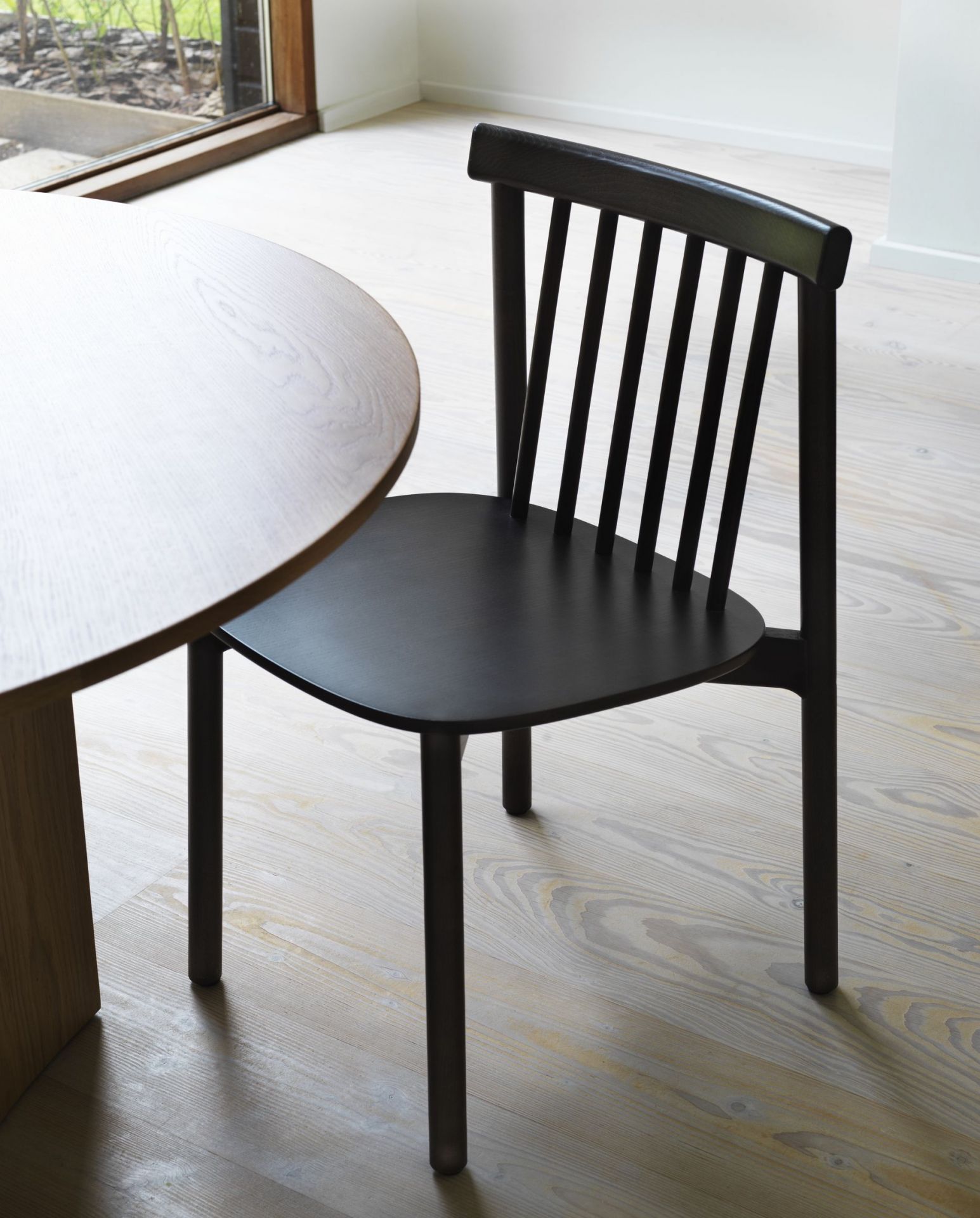 Schwarzer Pind Chair Stuhl von Normann Copenhagen aus Holz neben einem runden Tisch.