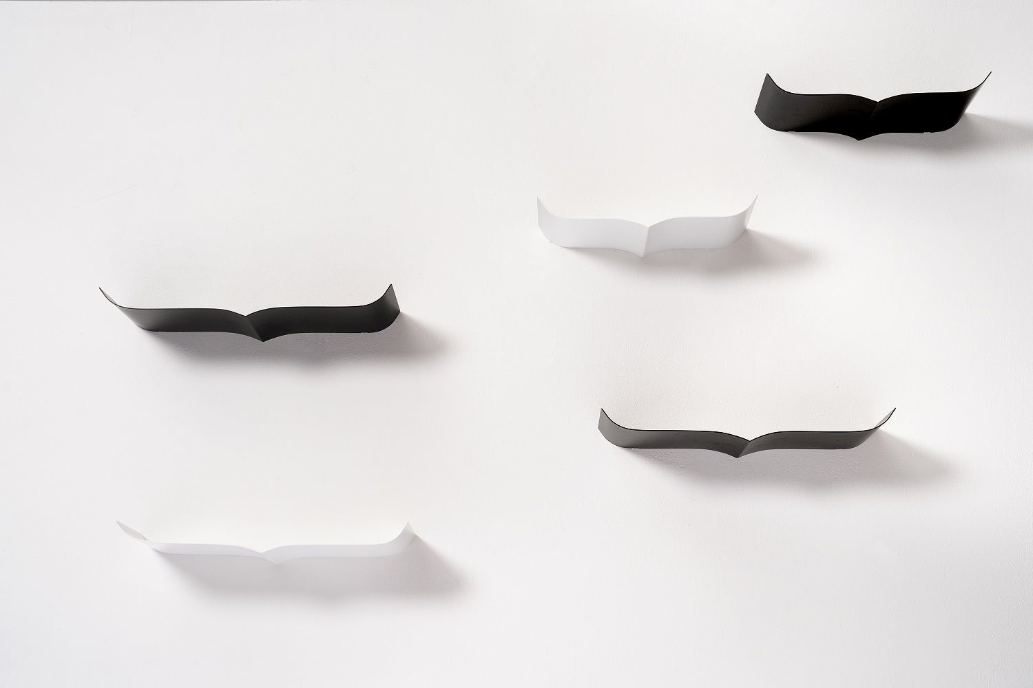 Wandmontierte Nori Regale von Opinion Ciatti in Schwarz und Weiß auf weißer Wand.