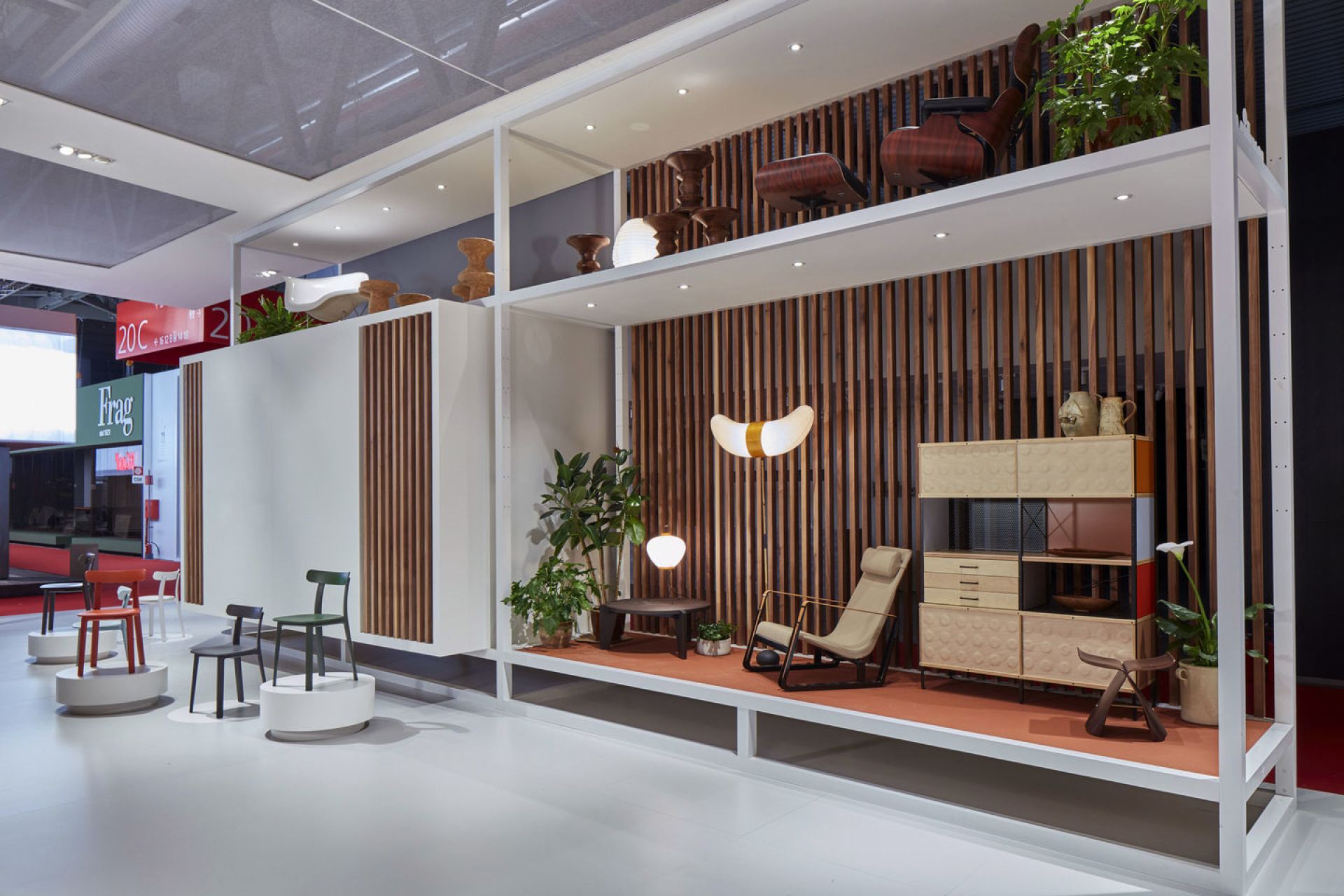 Ausstellungsstand mit Möbeln, darunter ein Butterfly Stool Hocker aus Holz. Vitra Design.