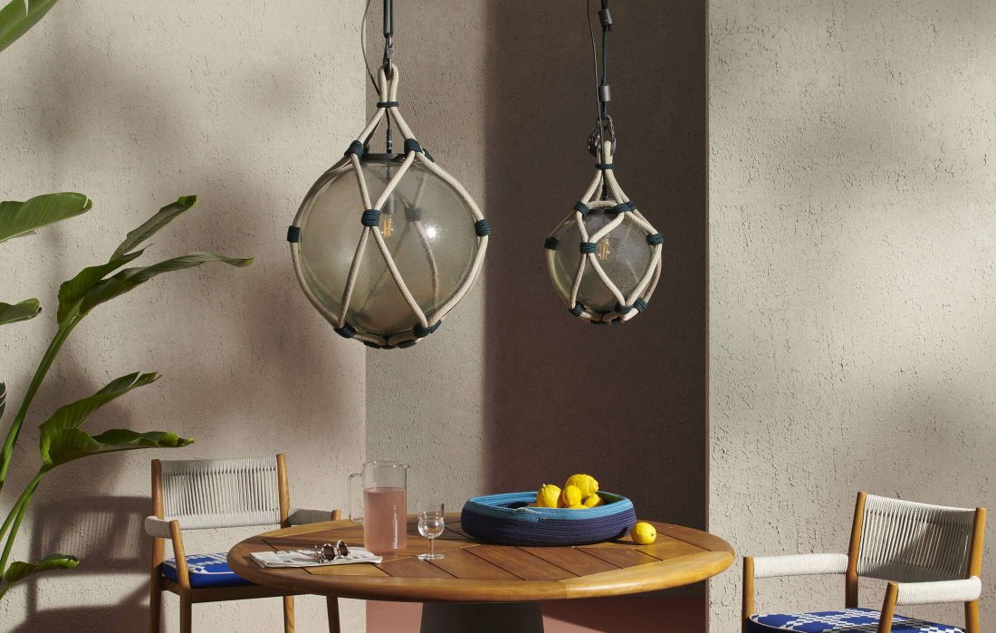 Zwei Bollicosa Nautilus Pendelleuchten von Cassina hängen über einem Outdoor-Esstisch. Moderne Außenleuchte mit Seil.
