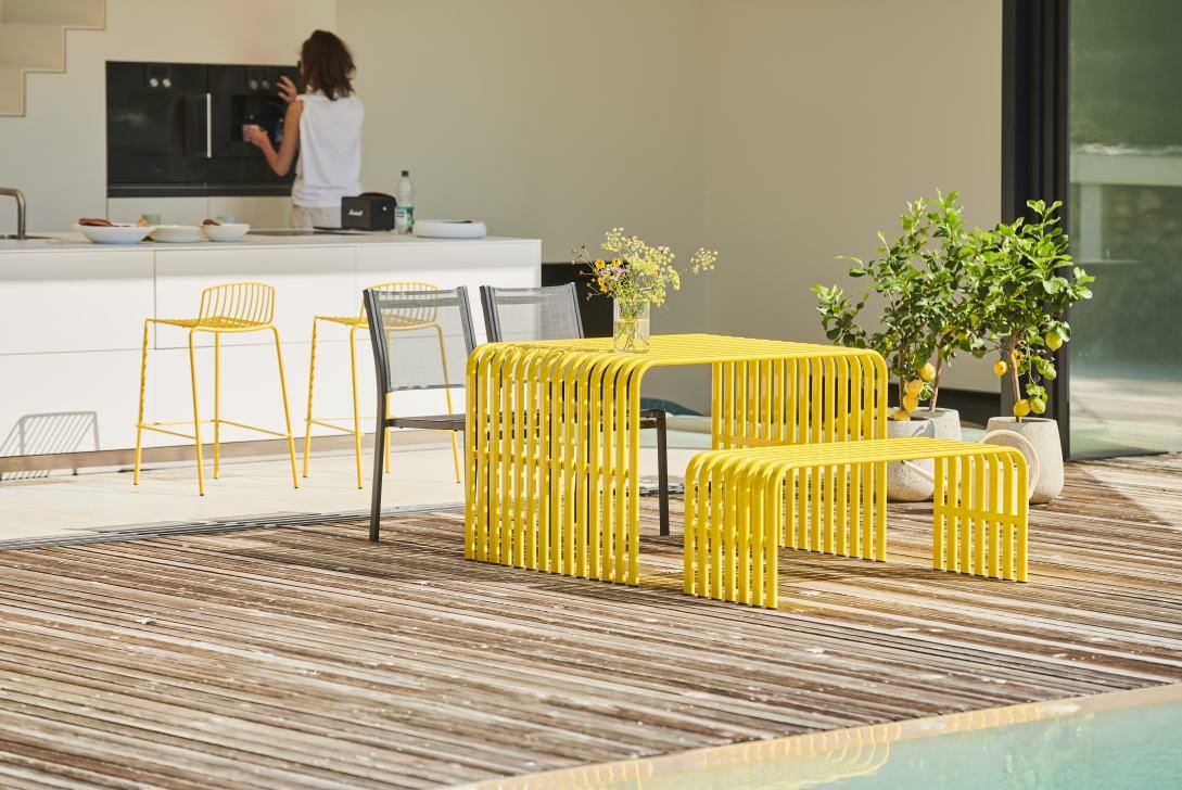 Gelber Jan Kurtz Campus Tisch mit Bank und Stühlen für den Outdoor-Bereich.